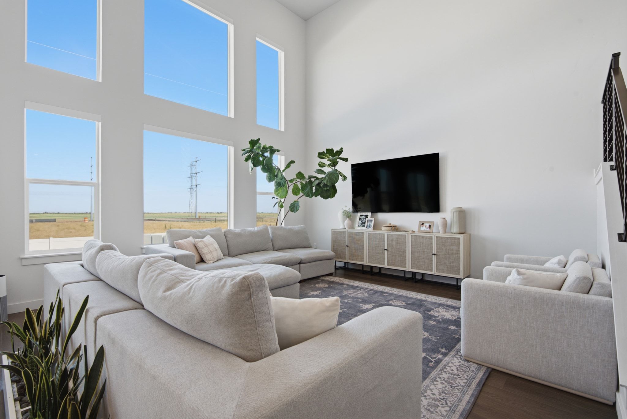 Vaulted ceiling living area featuring multiple floor-to-ceiling windows