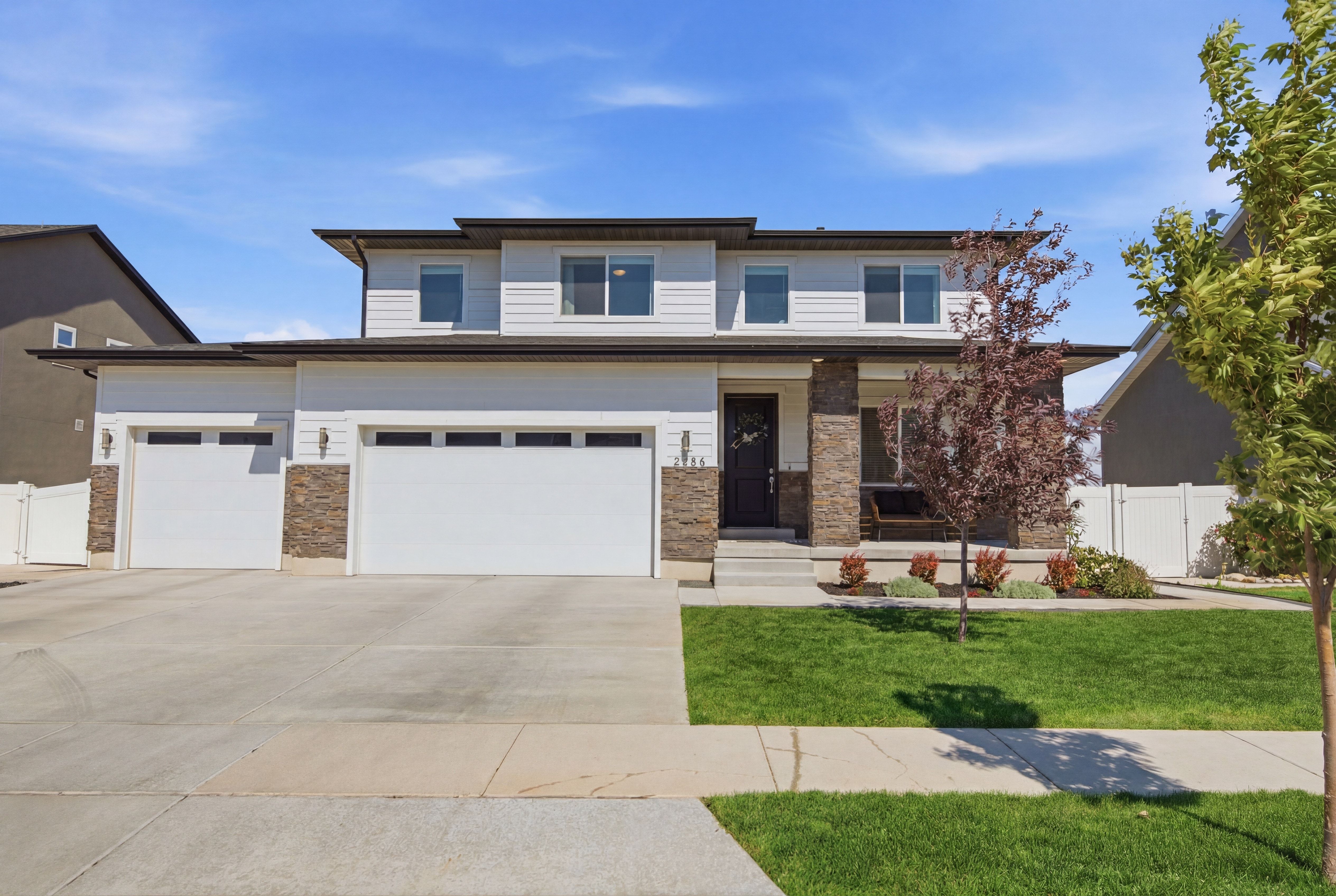 Contemporary two-story residence featuring light siding and dark trim accents