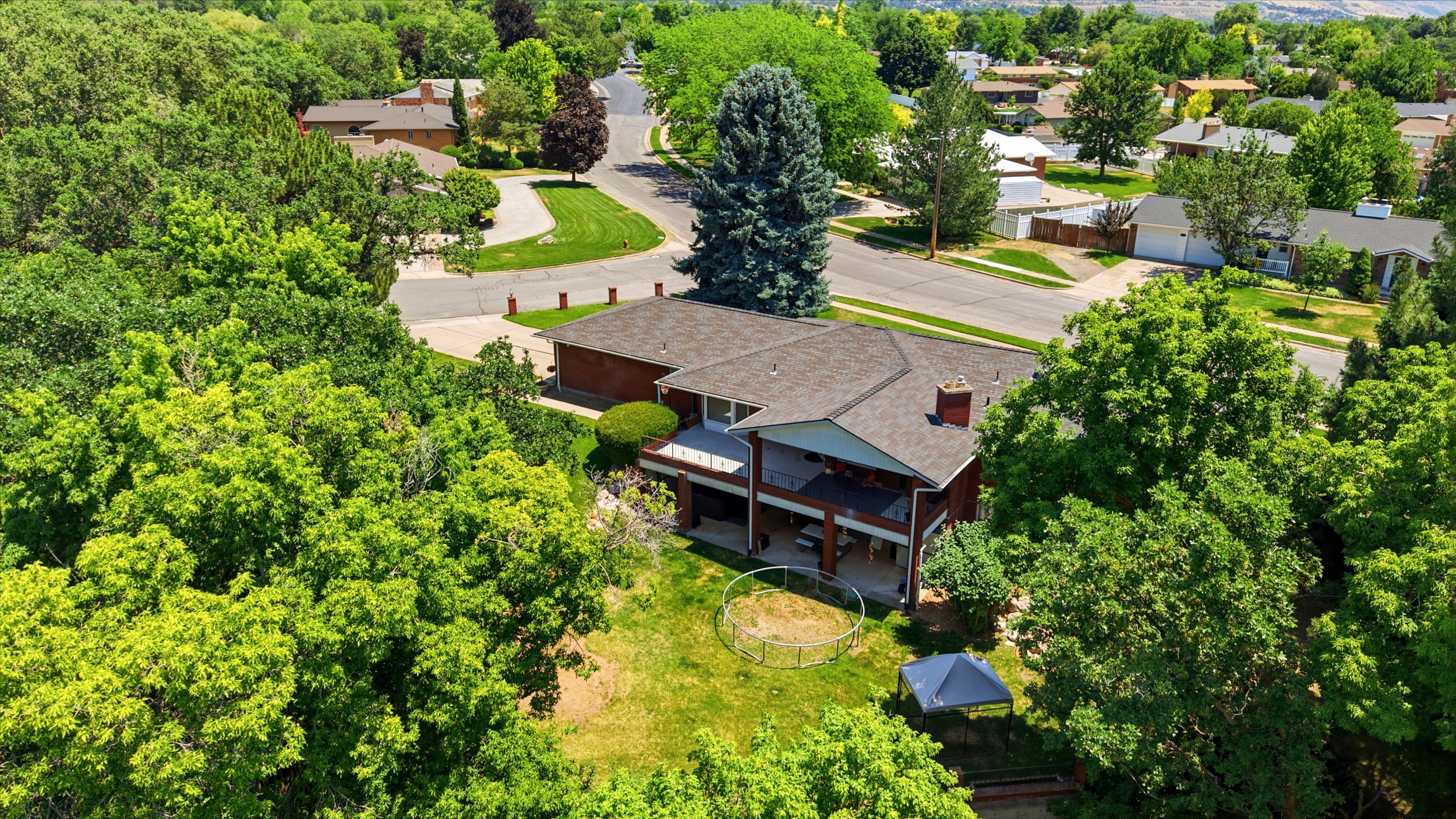 Expansive property featuring a multi-level house with a covered patio and upper-level balcony