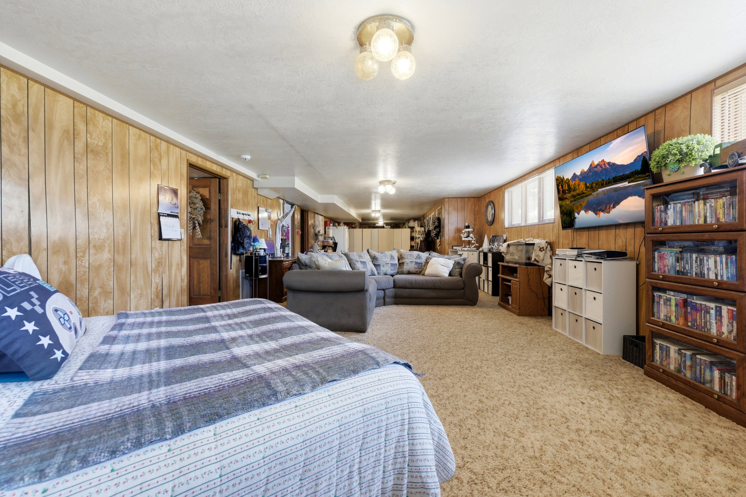 Spacious room featuring wood paneling, recessed lighting, and a neutral carpeted floor