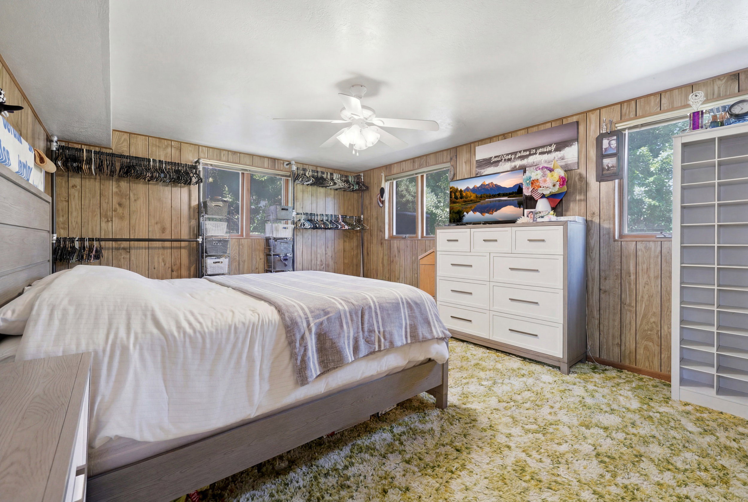 Bedroom with wood-paneled walls and a ceiling fan