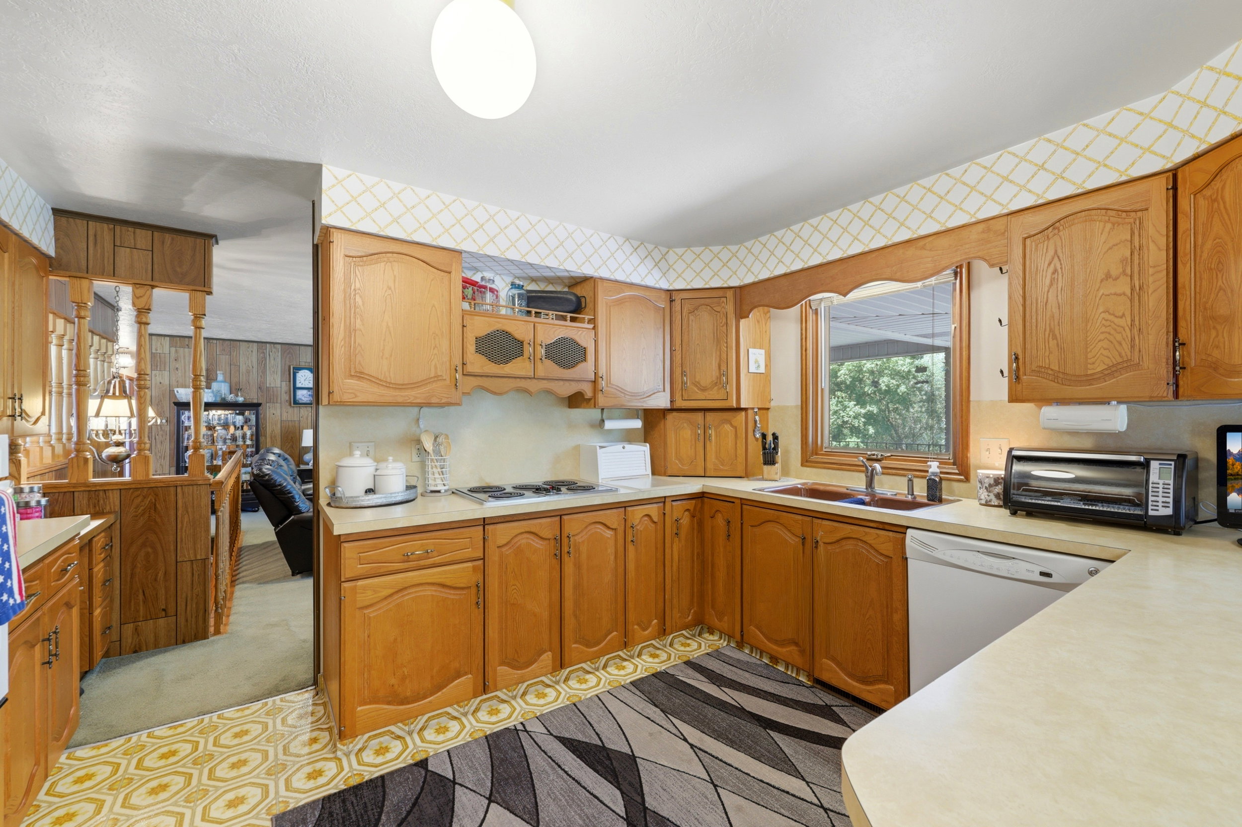 Kitchen featuring wood cabinetry, laminate countertops, and patterned vinyl flooring