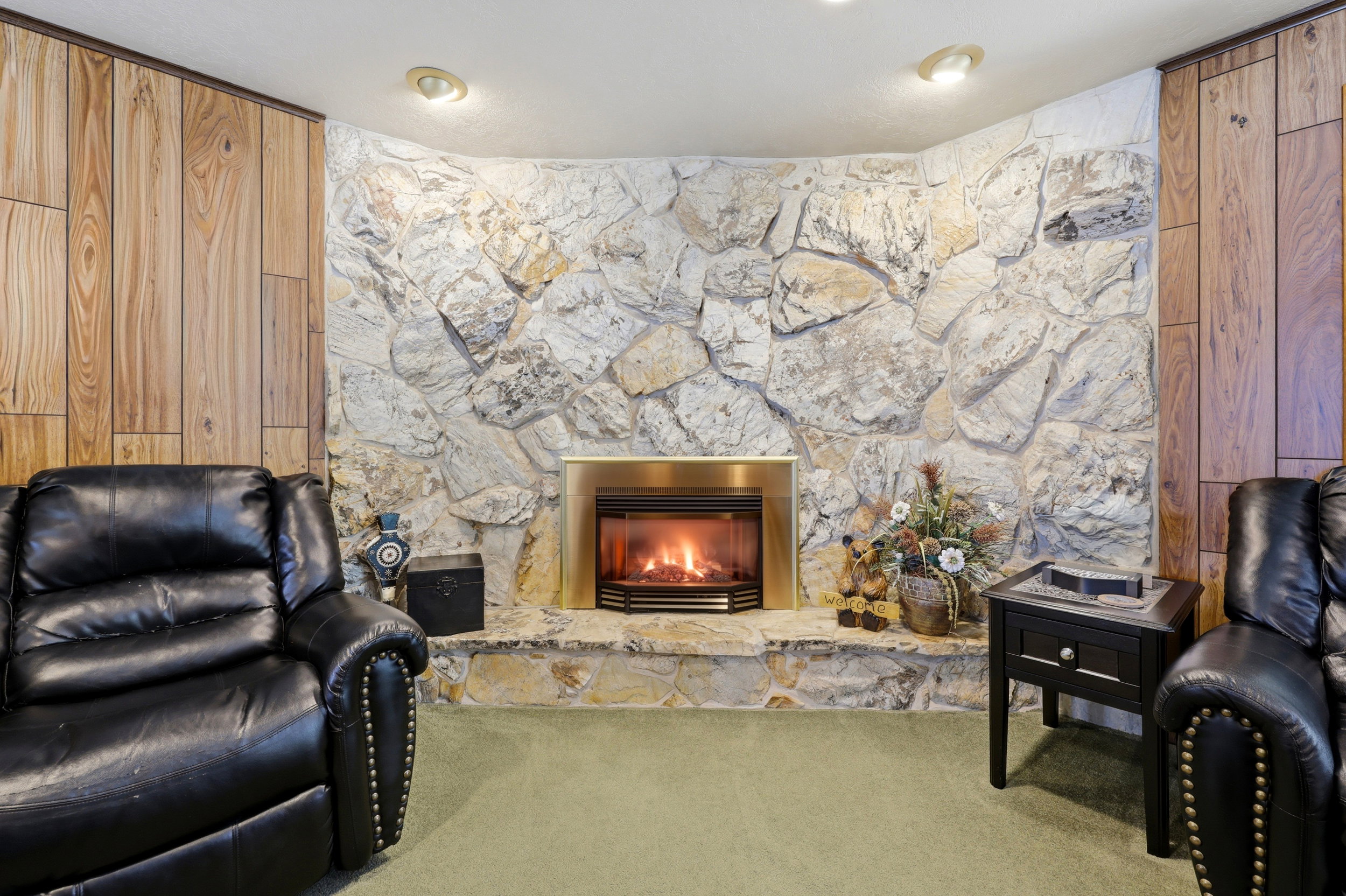 Stone-faced fireplace with a brass-toned insert and hearth