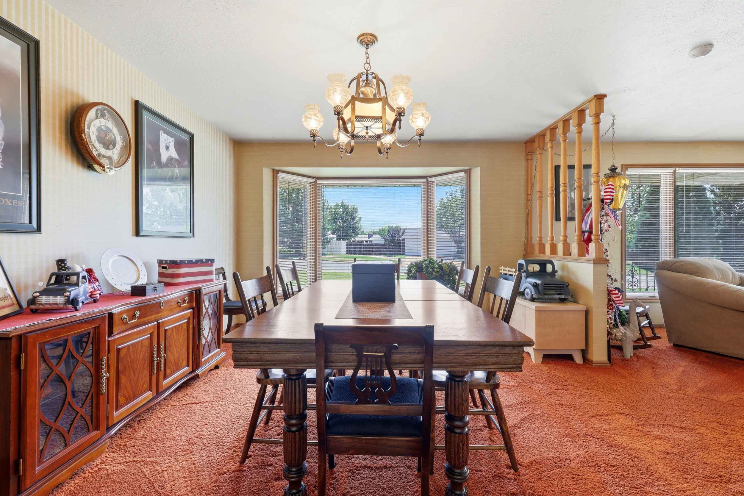 Dining area featuring a bay window, wood-finish flooring, and a chandelier