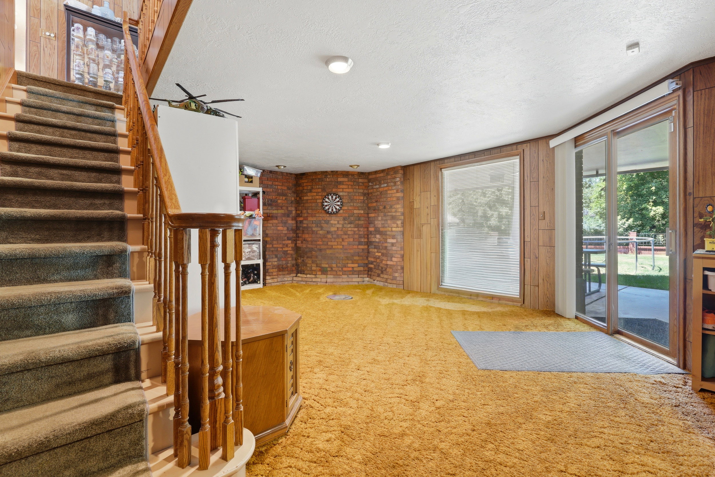 Staircase with wood railing and carpeted treads