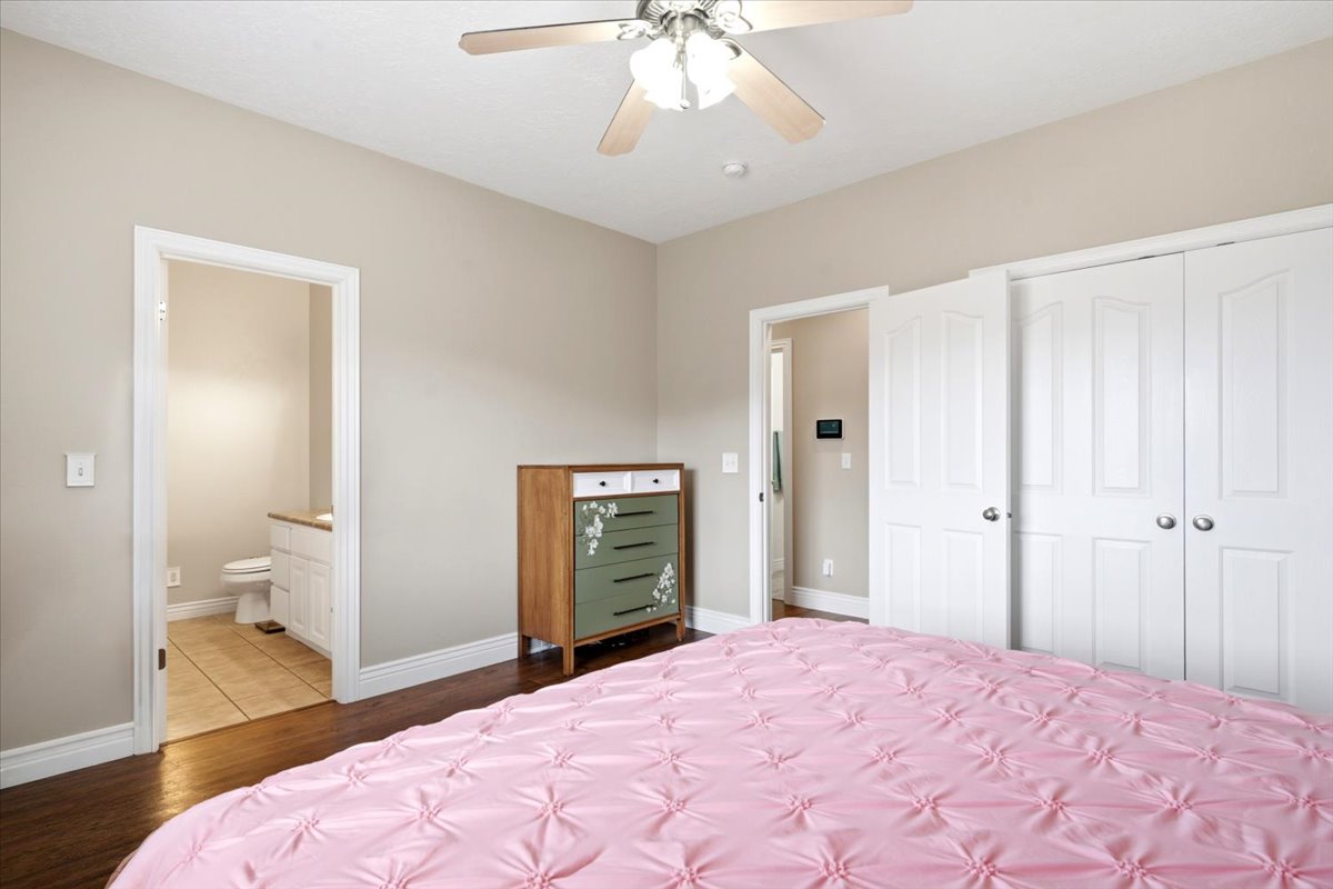 Bedroom featuring hardwood flooring, a ceiling fan with integrated lighting, and neutral wall tones
