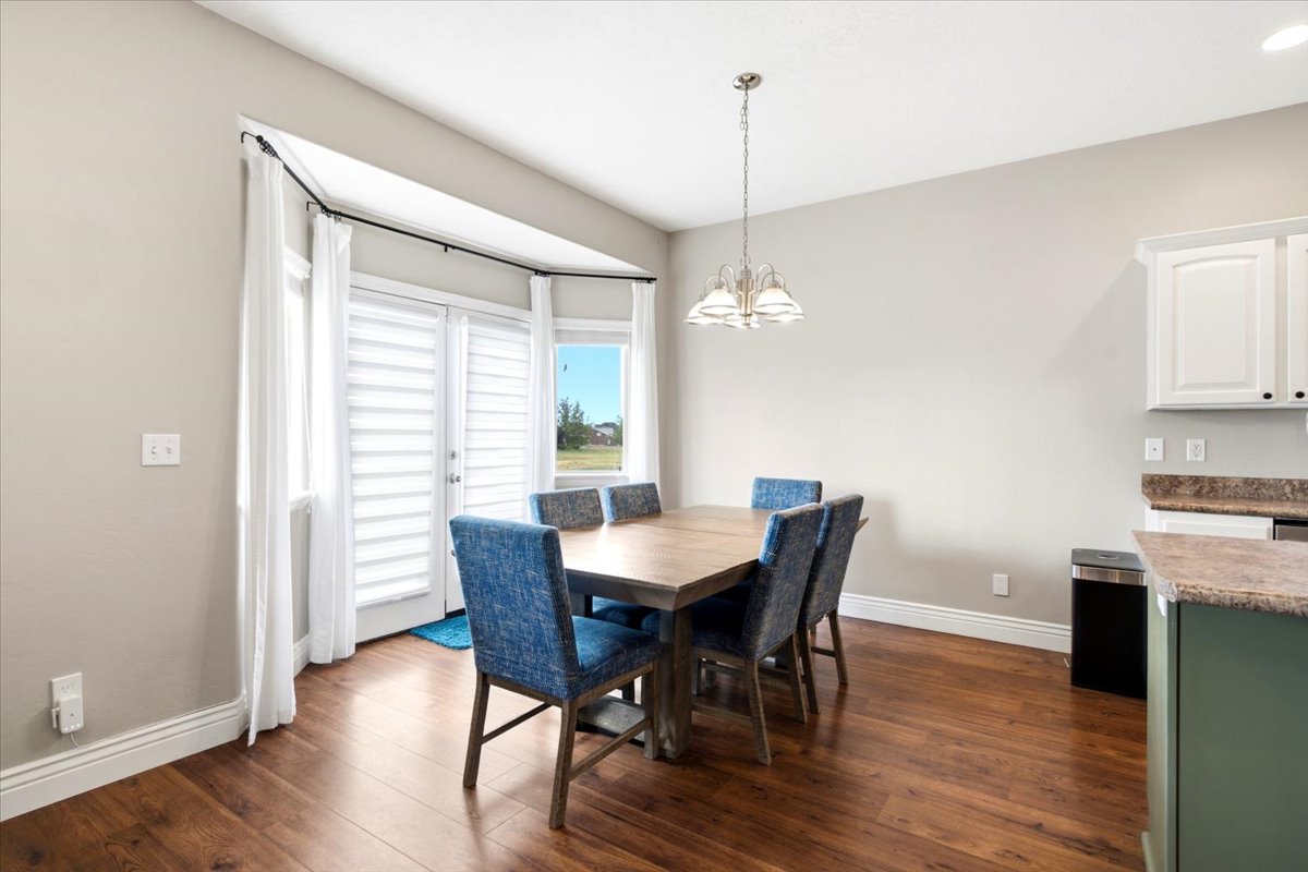 Dining area featuring wood-finish flooring and a bay window with a glass paneled door