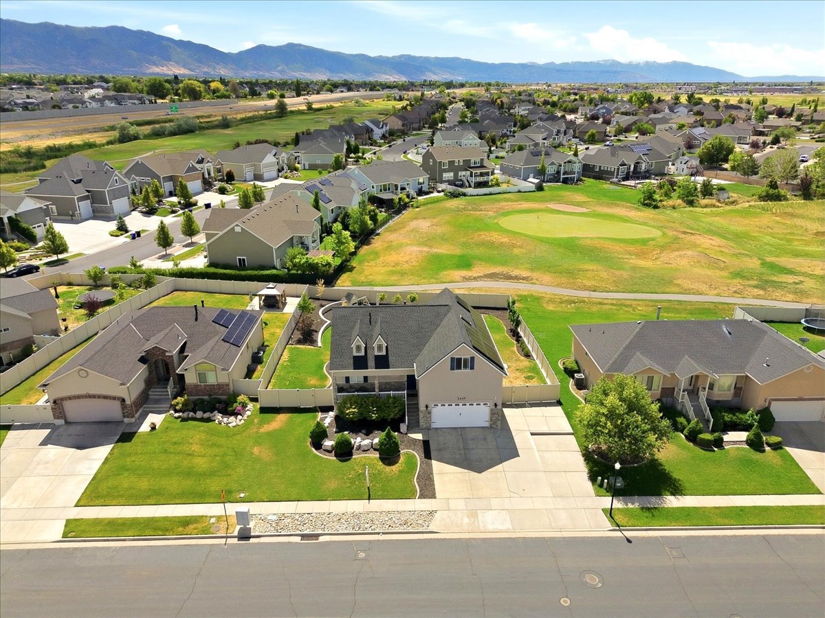 Suburban residence featuring a two-car garage, manicured lawn, and paved driveway