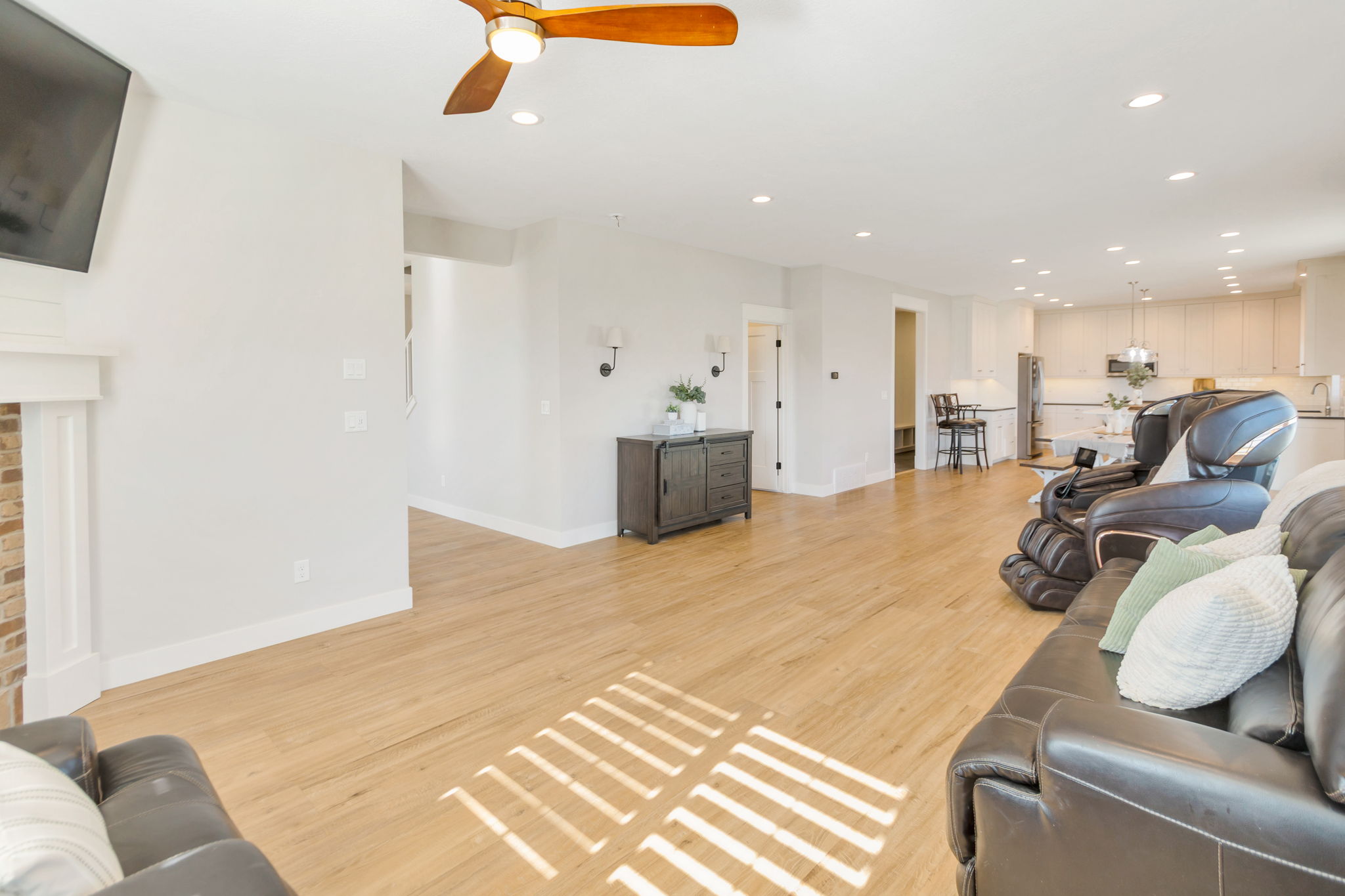 Open-concept living area featuring light wood-finish flooring, recessed lighting, and a ceiling fan