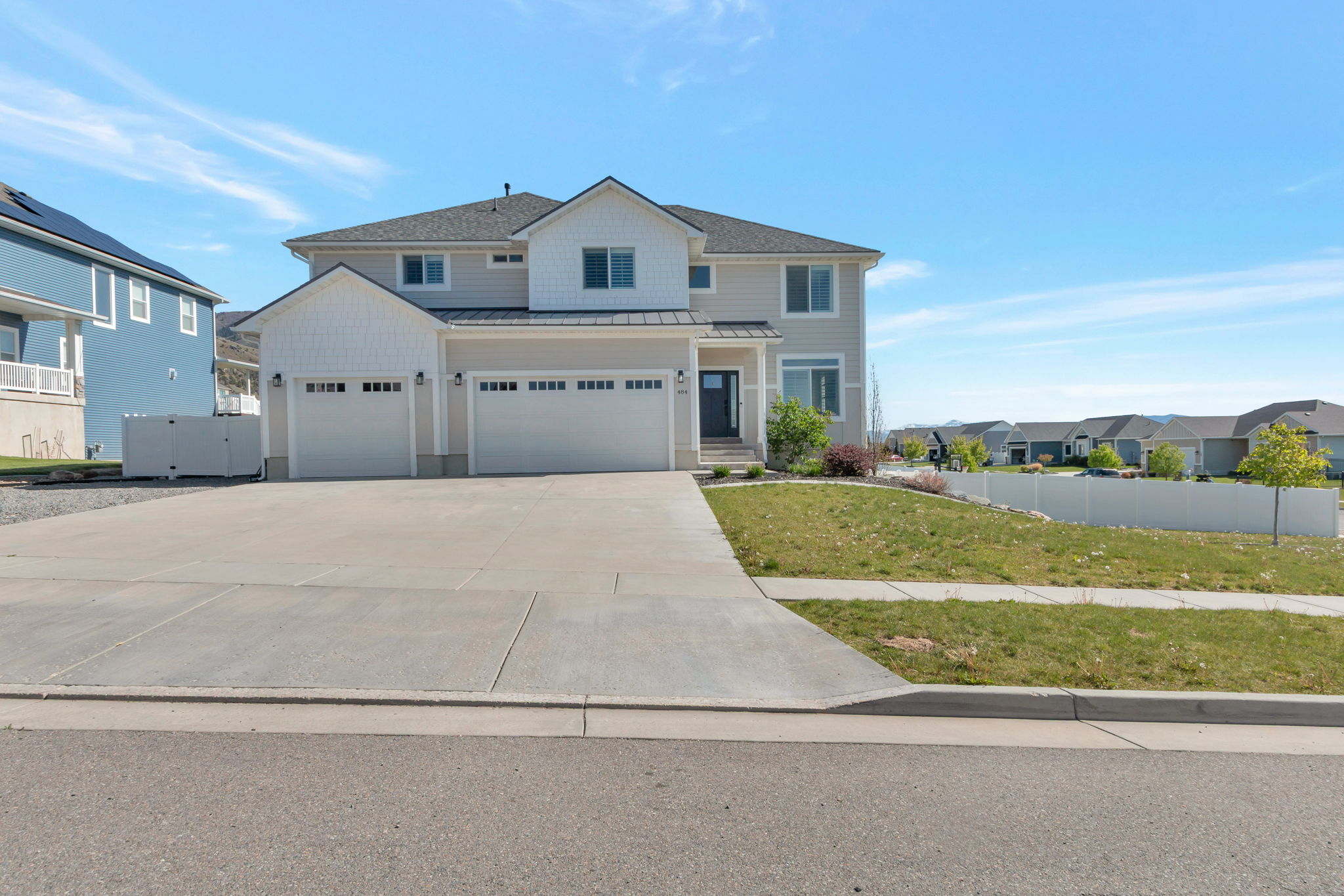 Modern traditional exterior featuring light gray siding, white trim, and a dark asphalt shingle roof
