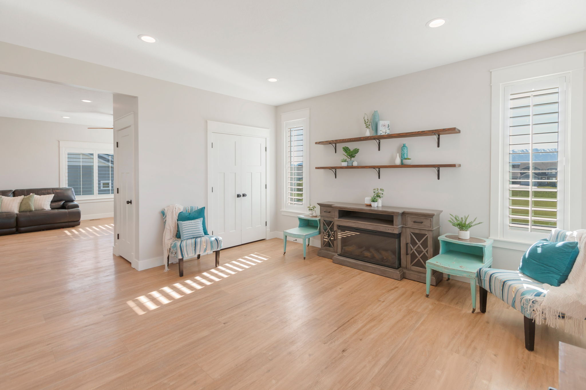 Spacious room featuring light wood-finish flooring, recessed lighting, and white walls