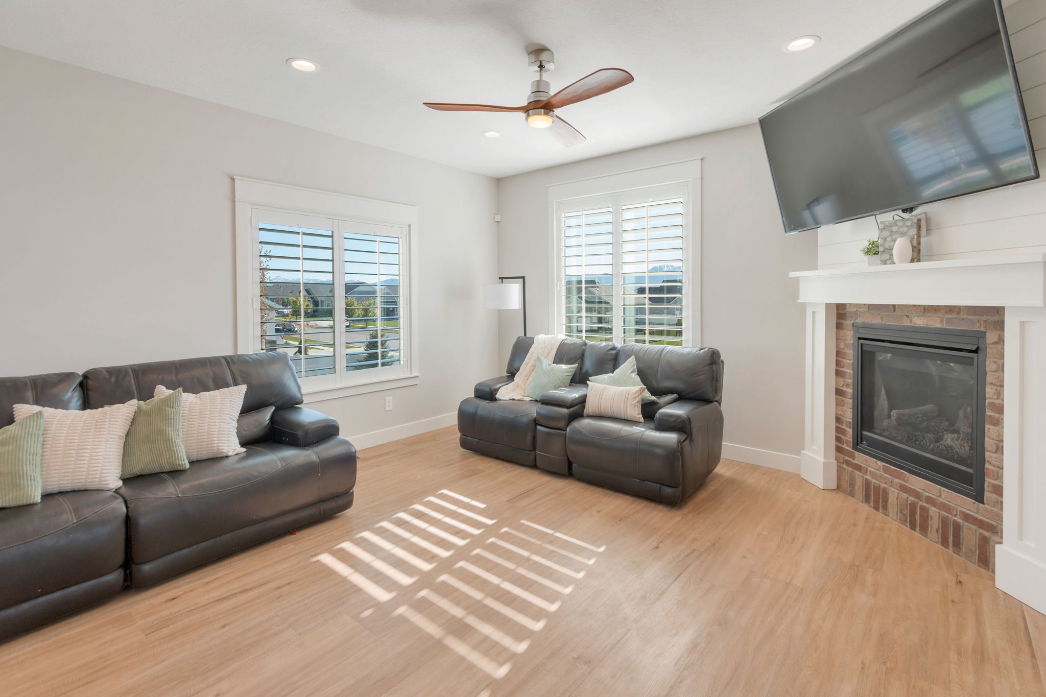 Living area featuring wood-finish flooring, recessed lighting, and a ceiling fan