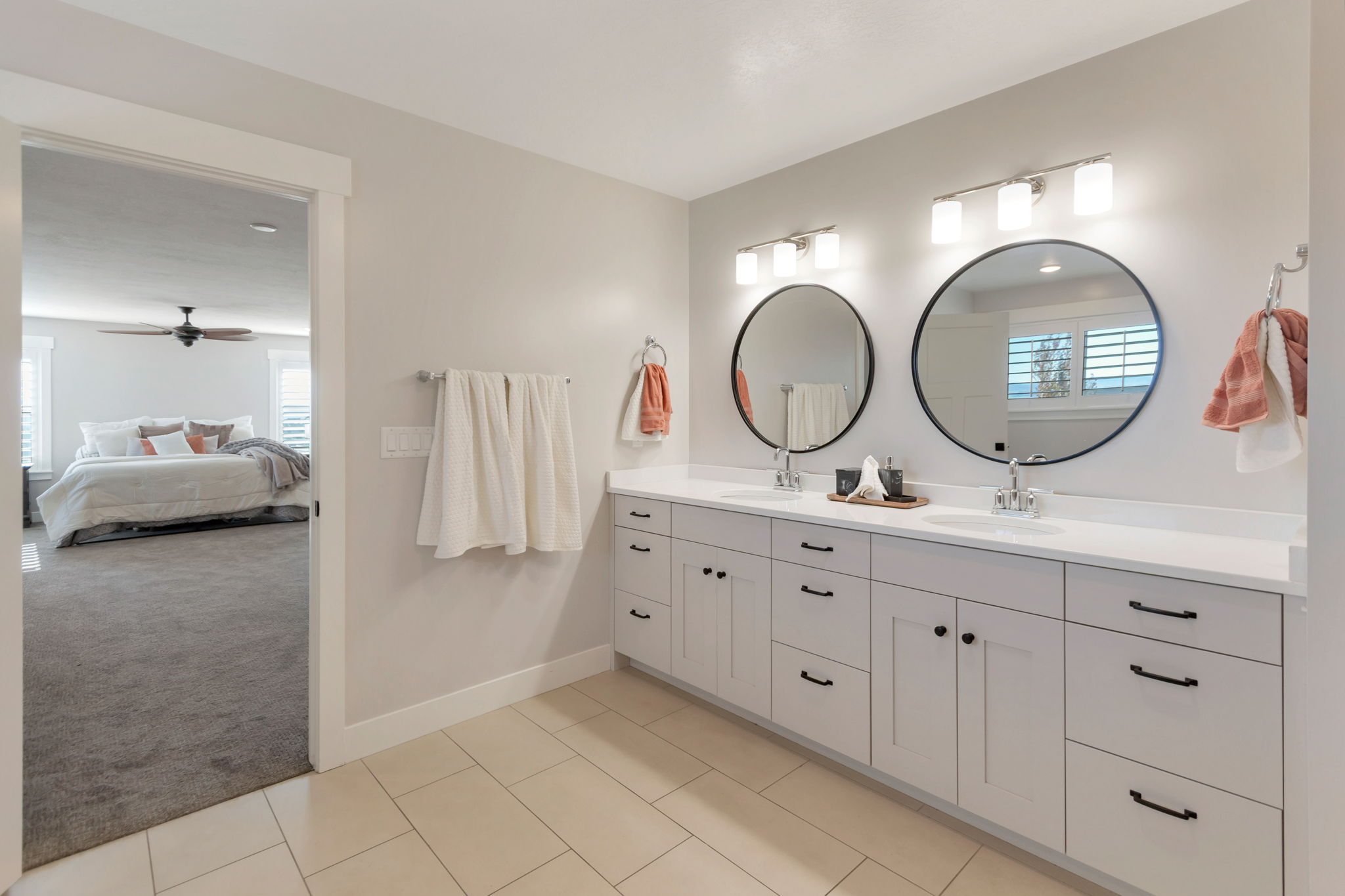 Double vanity with white countertops, dual undermount sinks, and matte black hardware