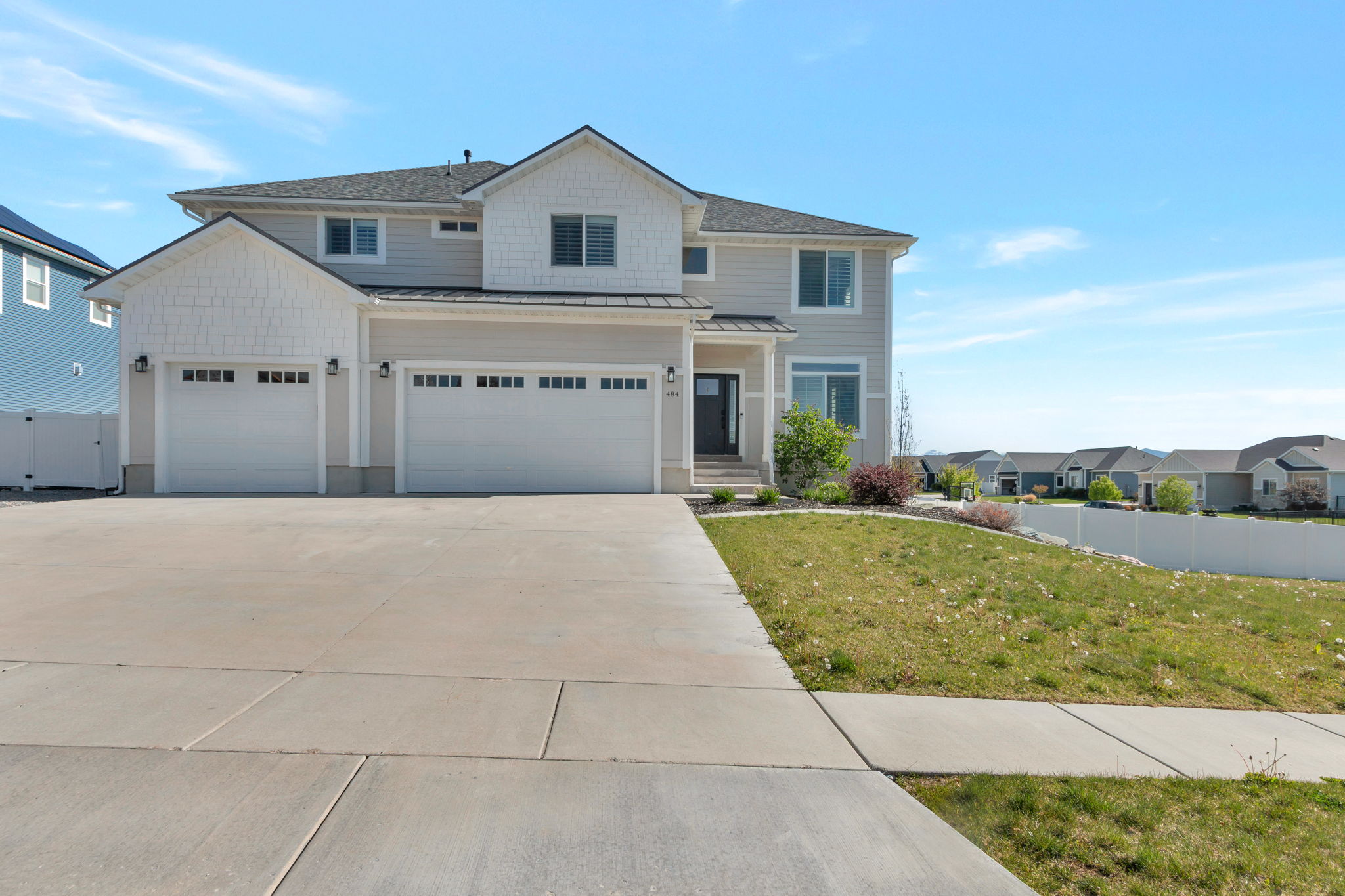 Contemporary two-story residence featuring a combination of light gray siding and white shake accents