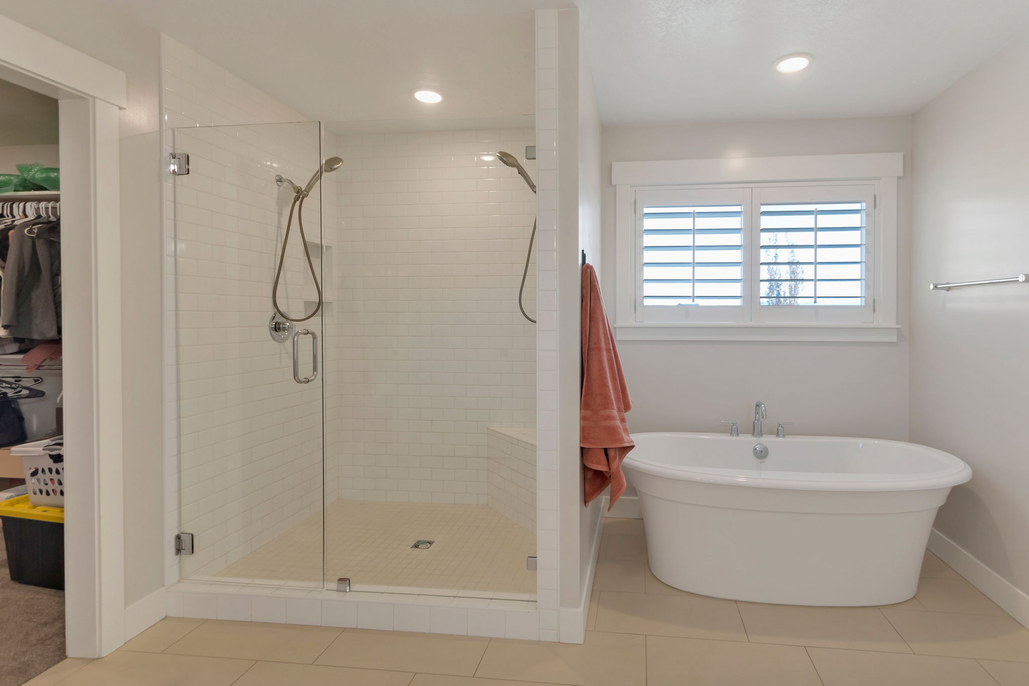 Freestanding soaking tub with a window featuring plantation shutters