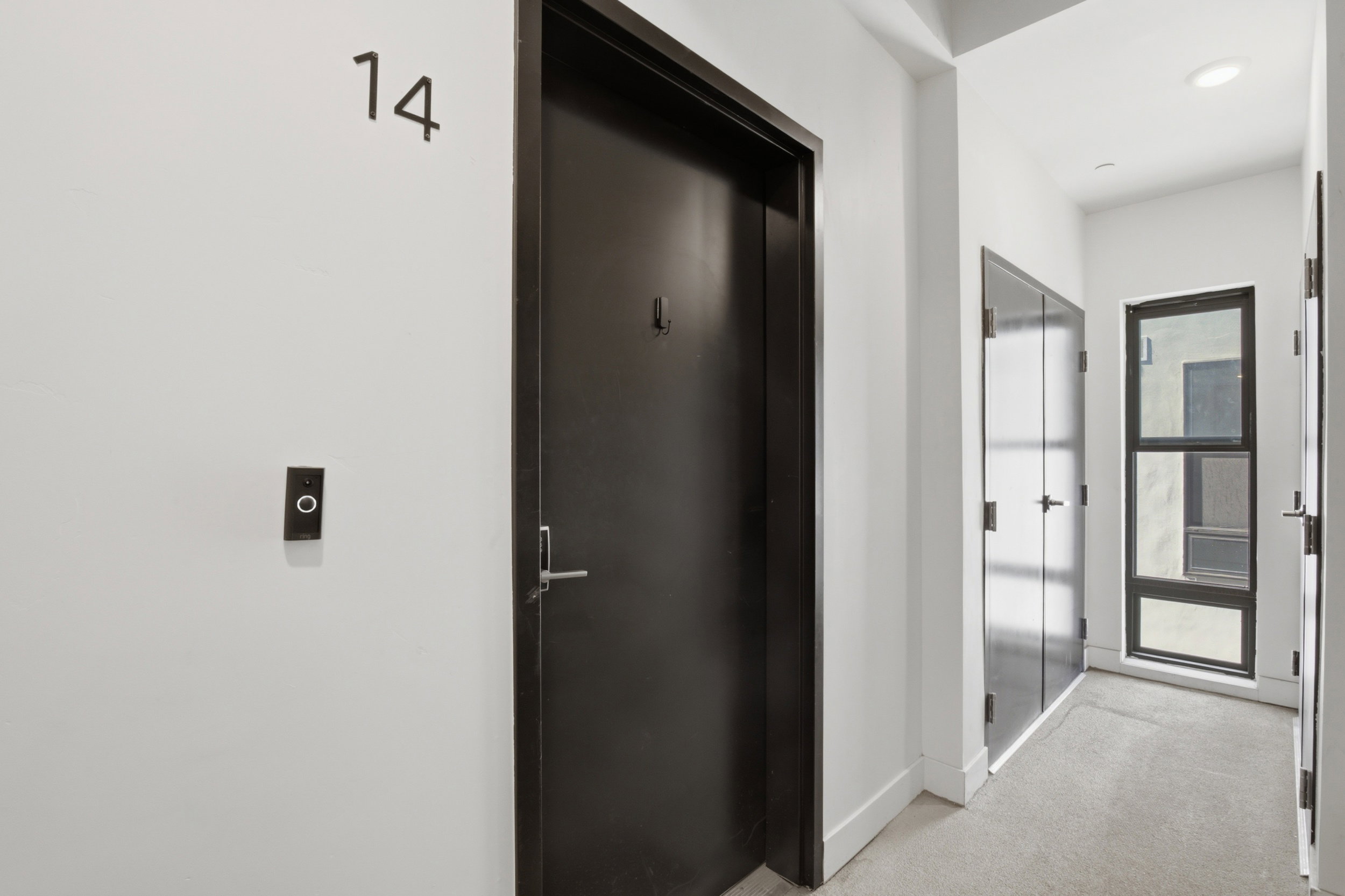 Front door to the condo and access to the mechanical room - we love a hallway window letting in natural light!