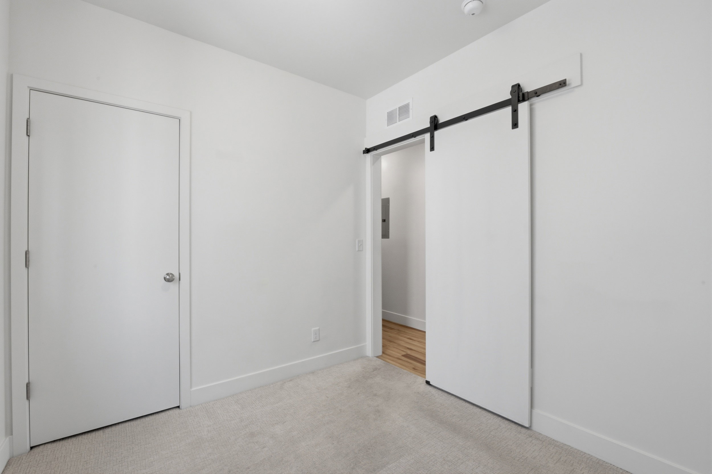Bedroom on the main level featuring a sliding barn door - also makes a great office space!