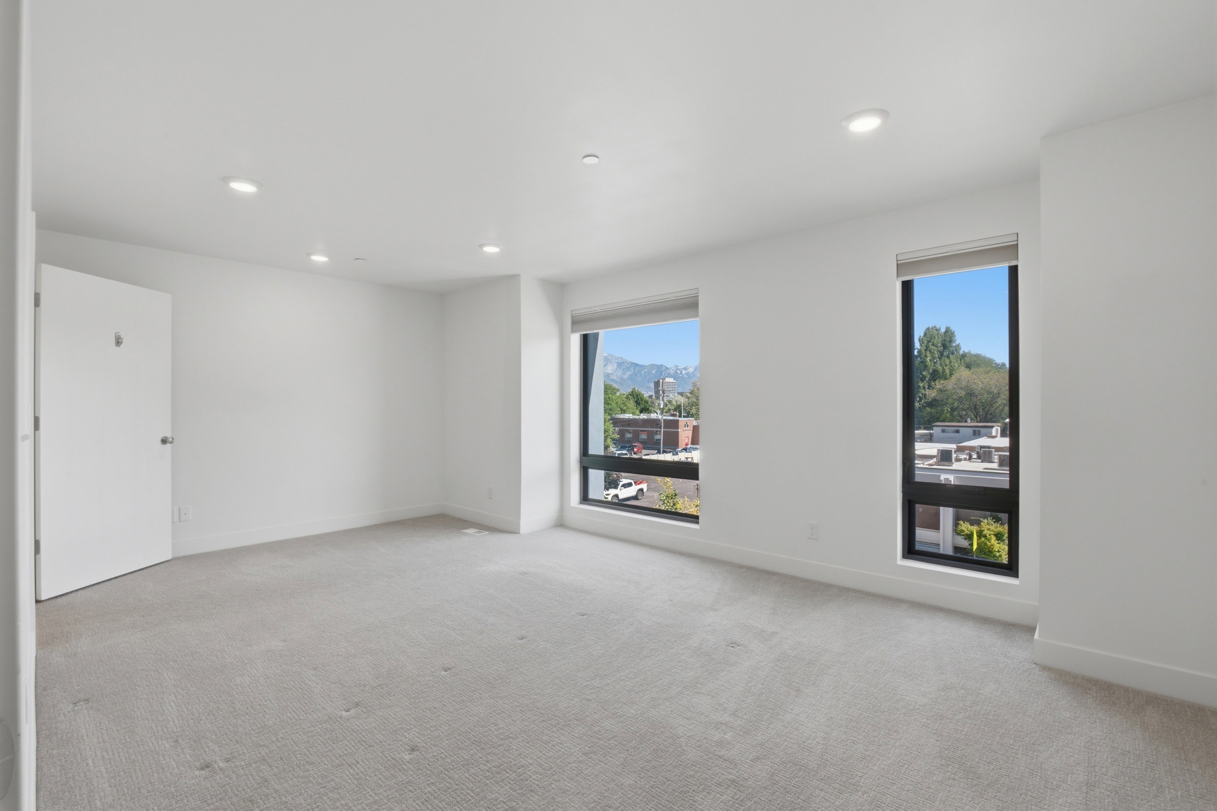 Spacious primary bedroom with large picture windows for lots of natural light