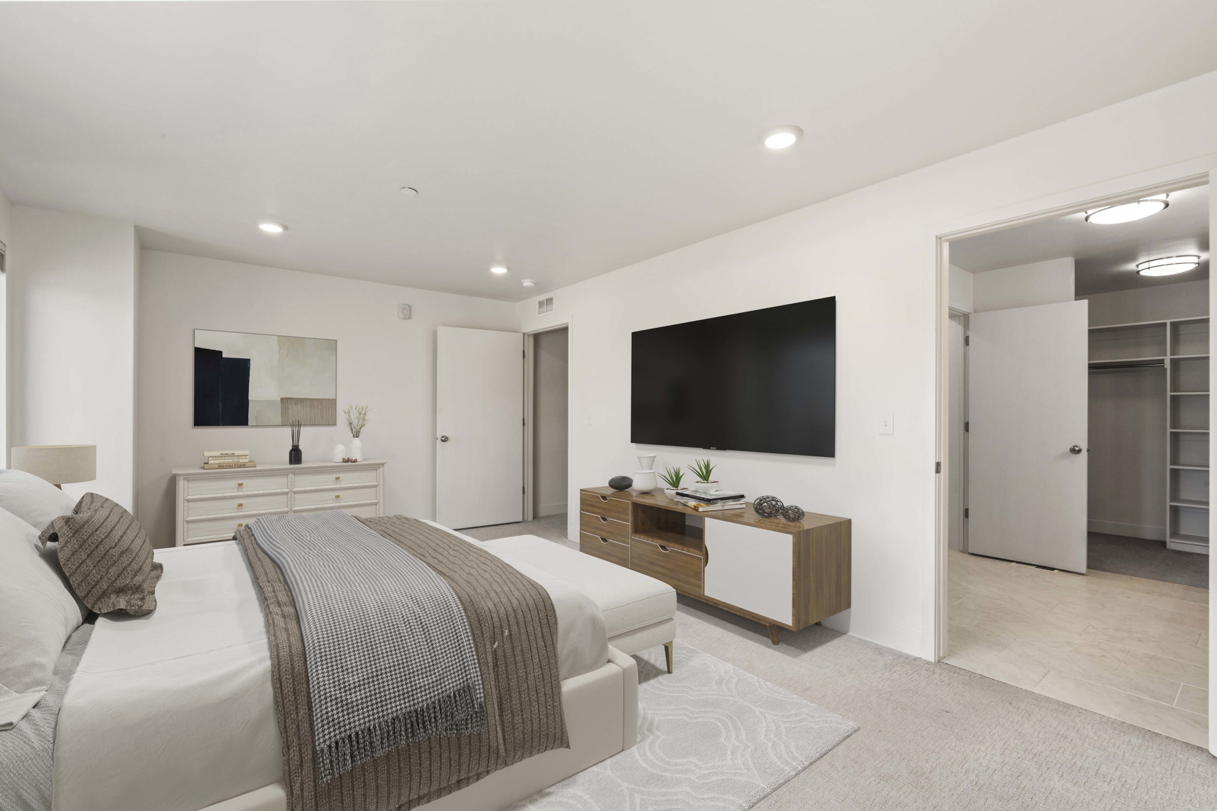 Spacious primary bedroom featuring an ensuite bathroom and large walk in closet