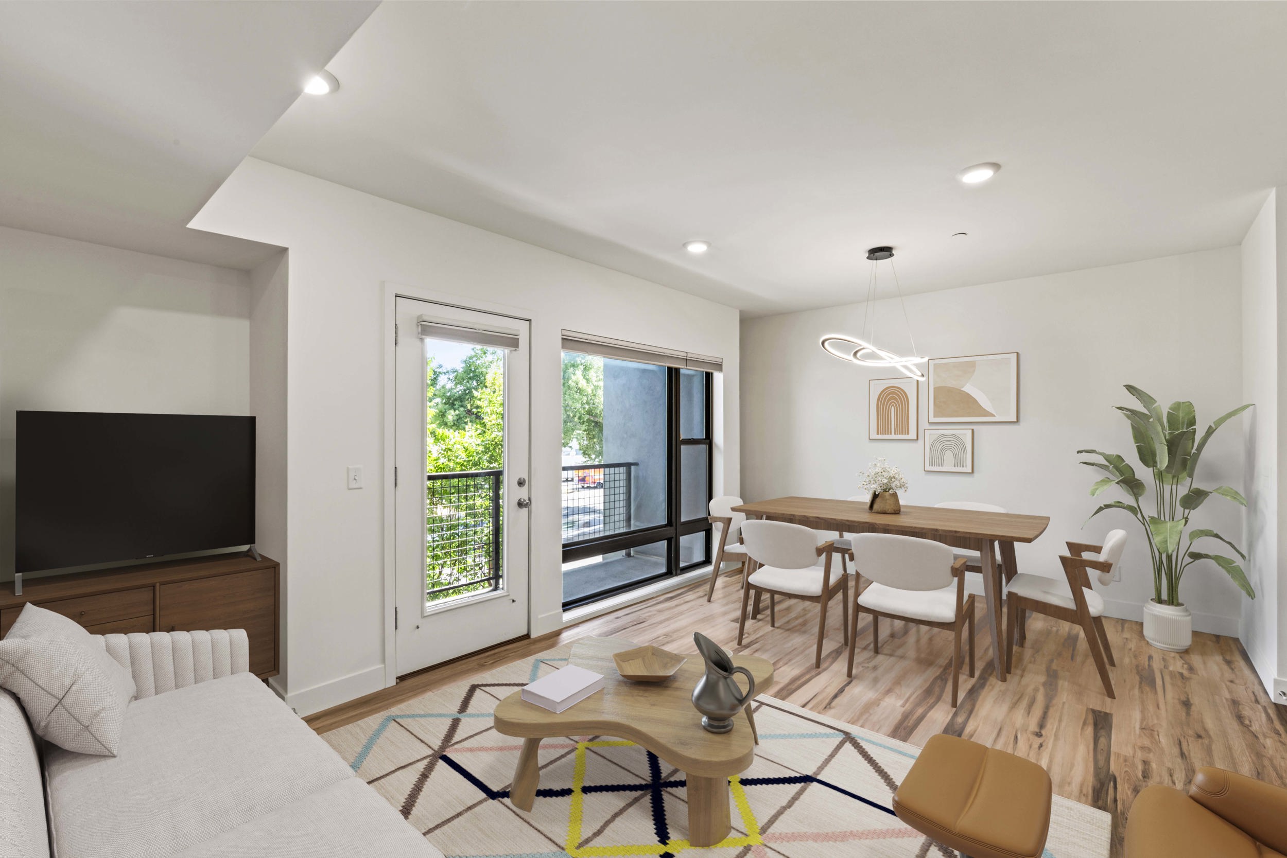 Open-concept living area featuring wood-finish flooring, recessed lighting, and a private balcony
