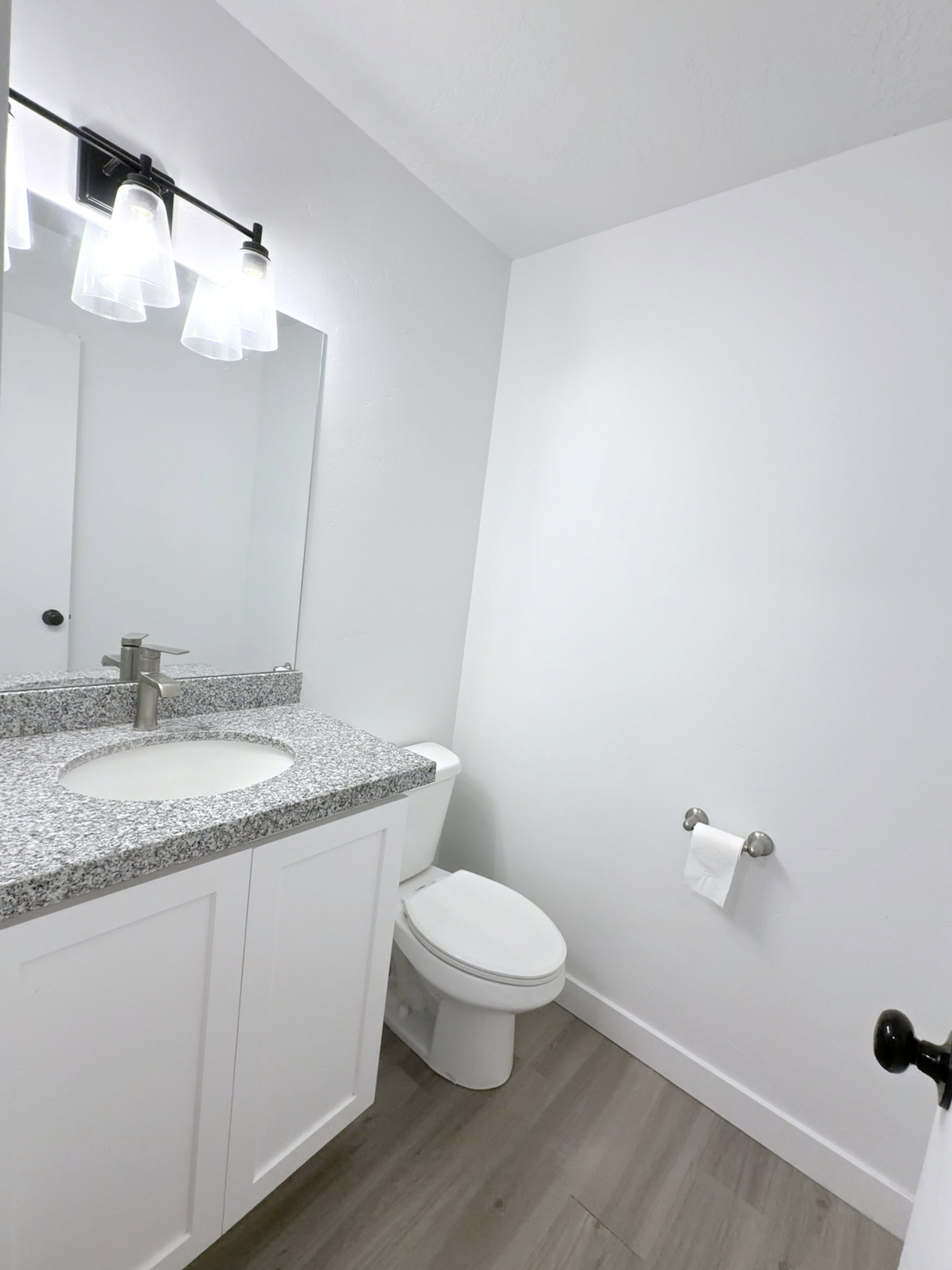 Bathroom featuring a white vanity with panel cabinetry, a granite-look countertop, and a circular undermount sink