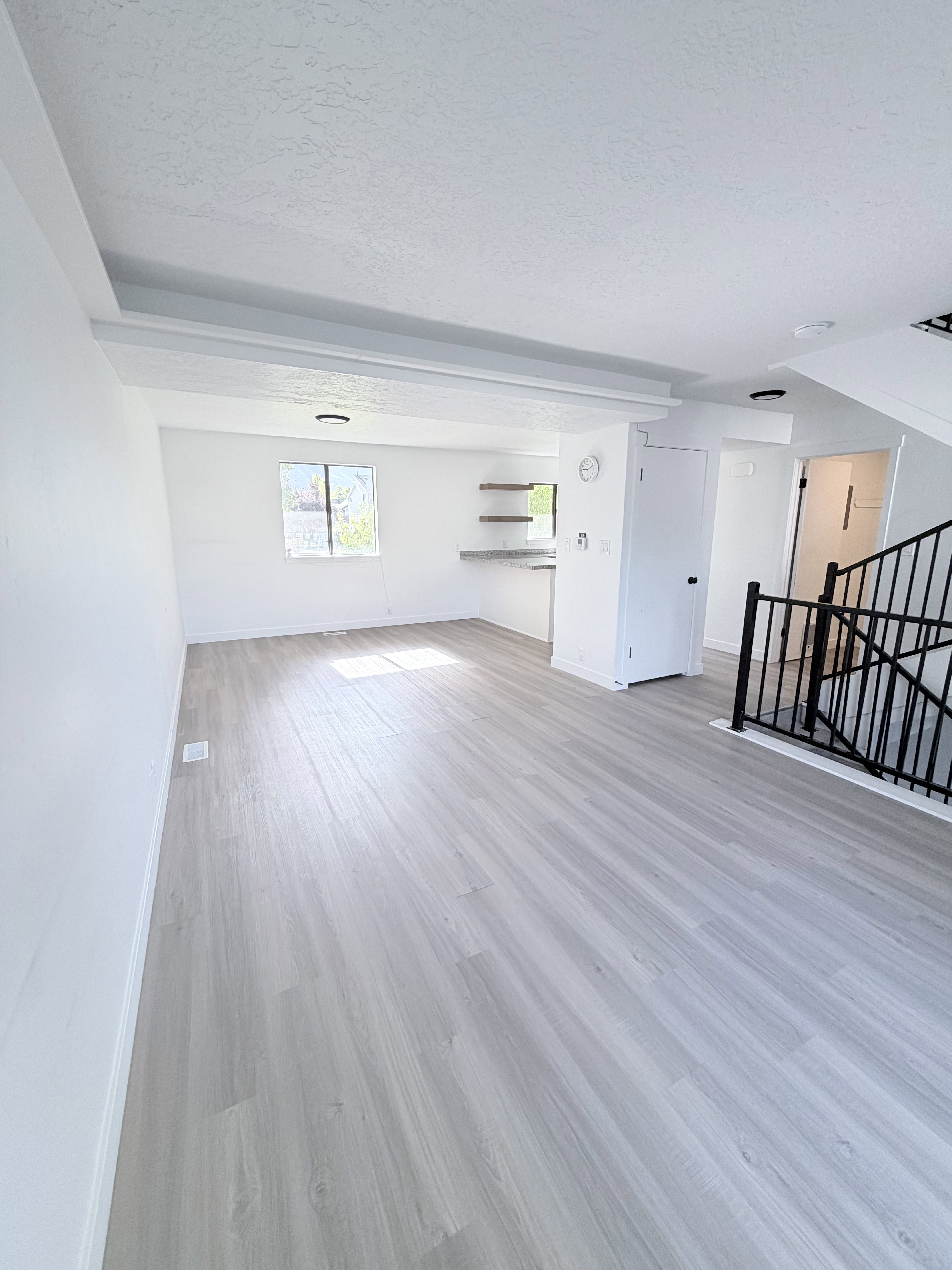 Light wood-finish flooring extending across the space
