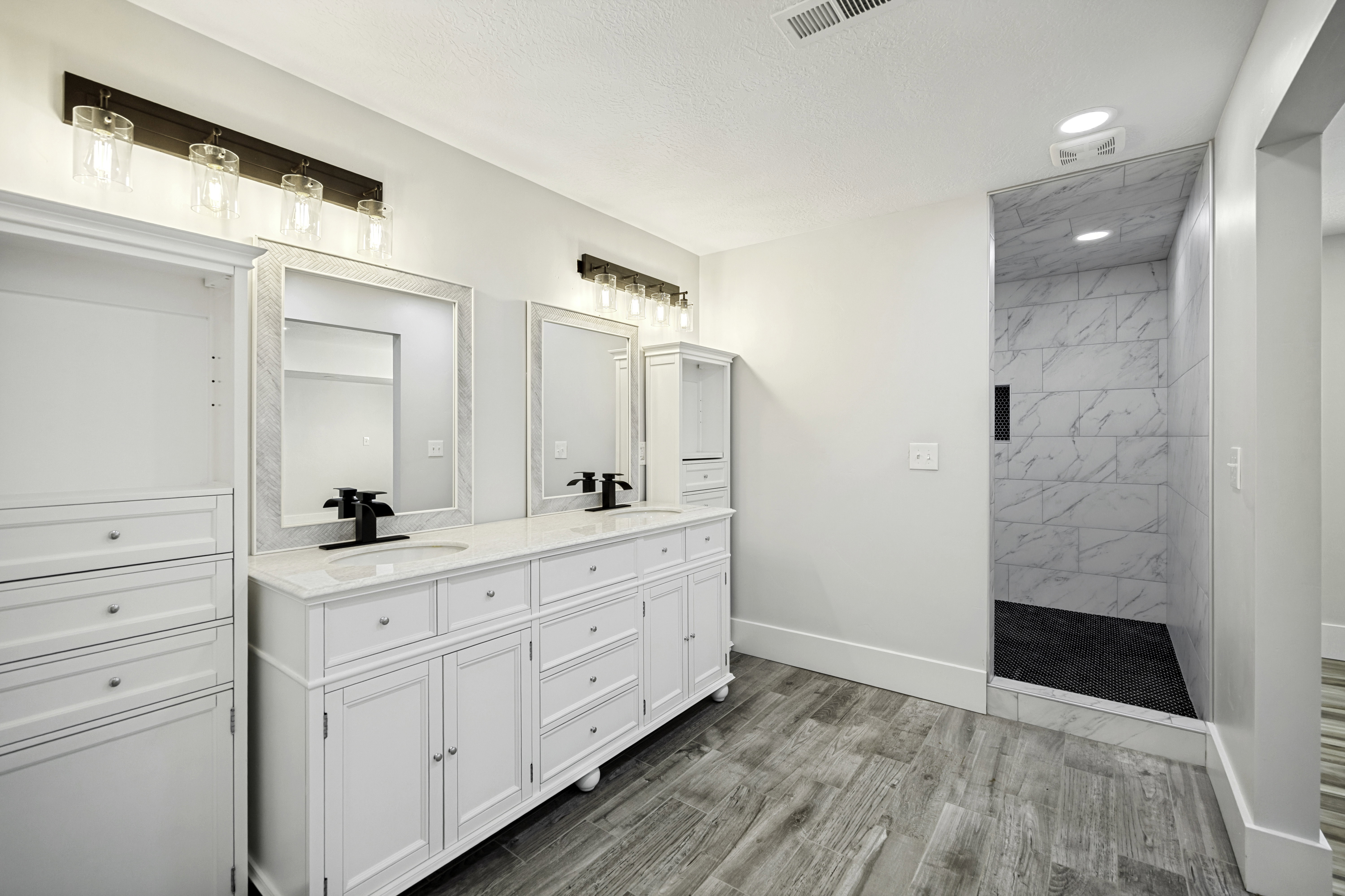 Dual vanity with white cabinetry and integrated sinks, quartz countertops, and matte black fixtures