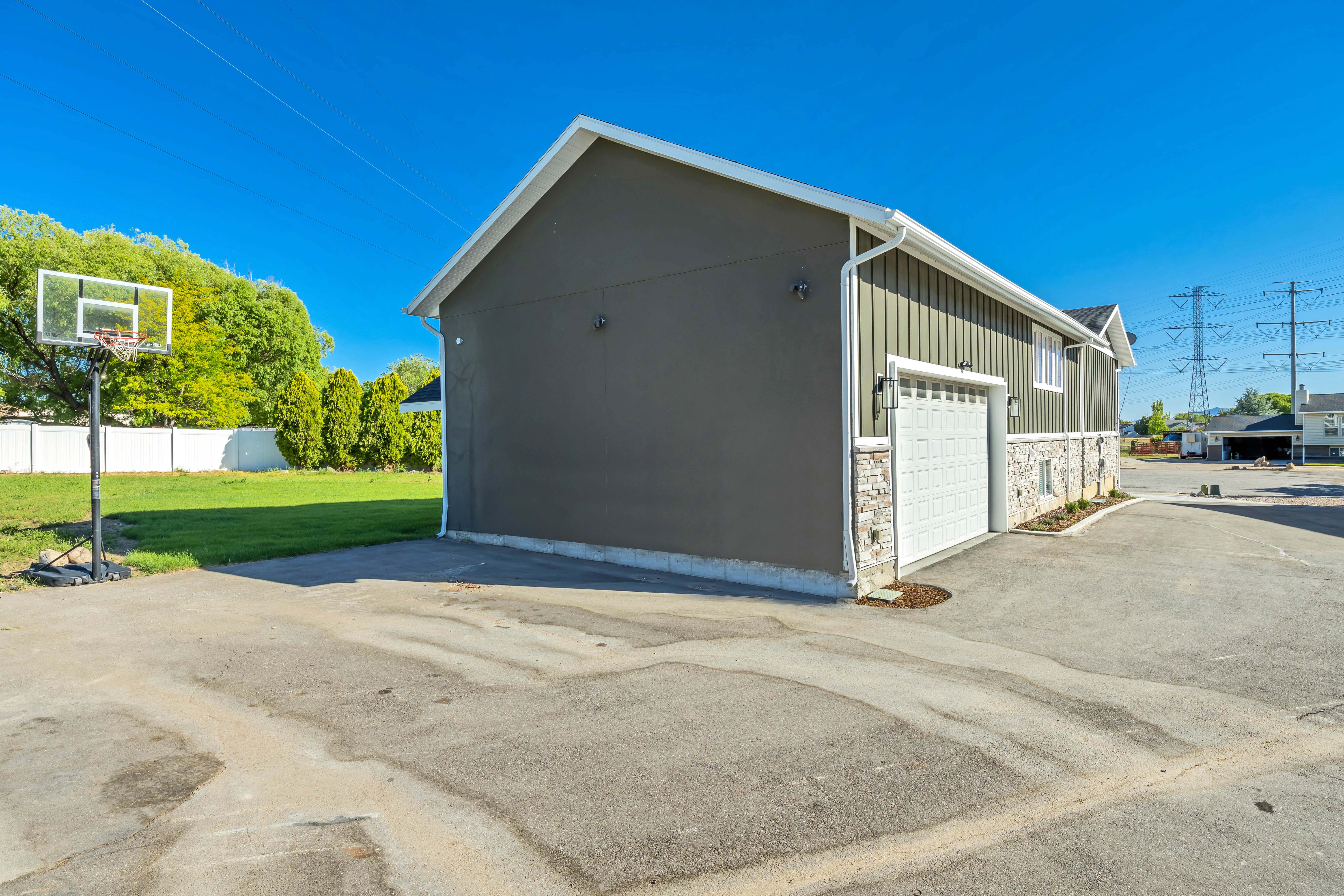 Exterior structure featuring a vertical siding facade, a white garage door, and a stone veneer foundation