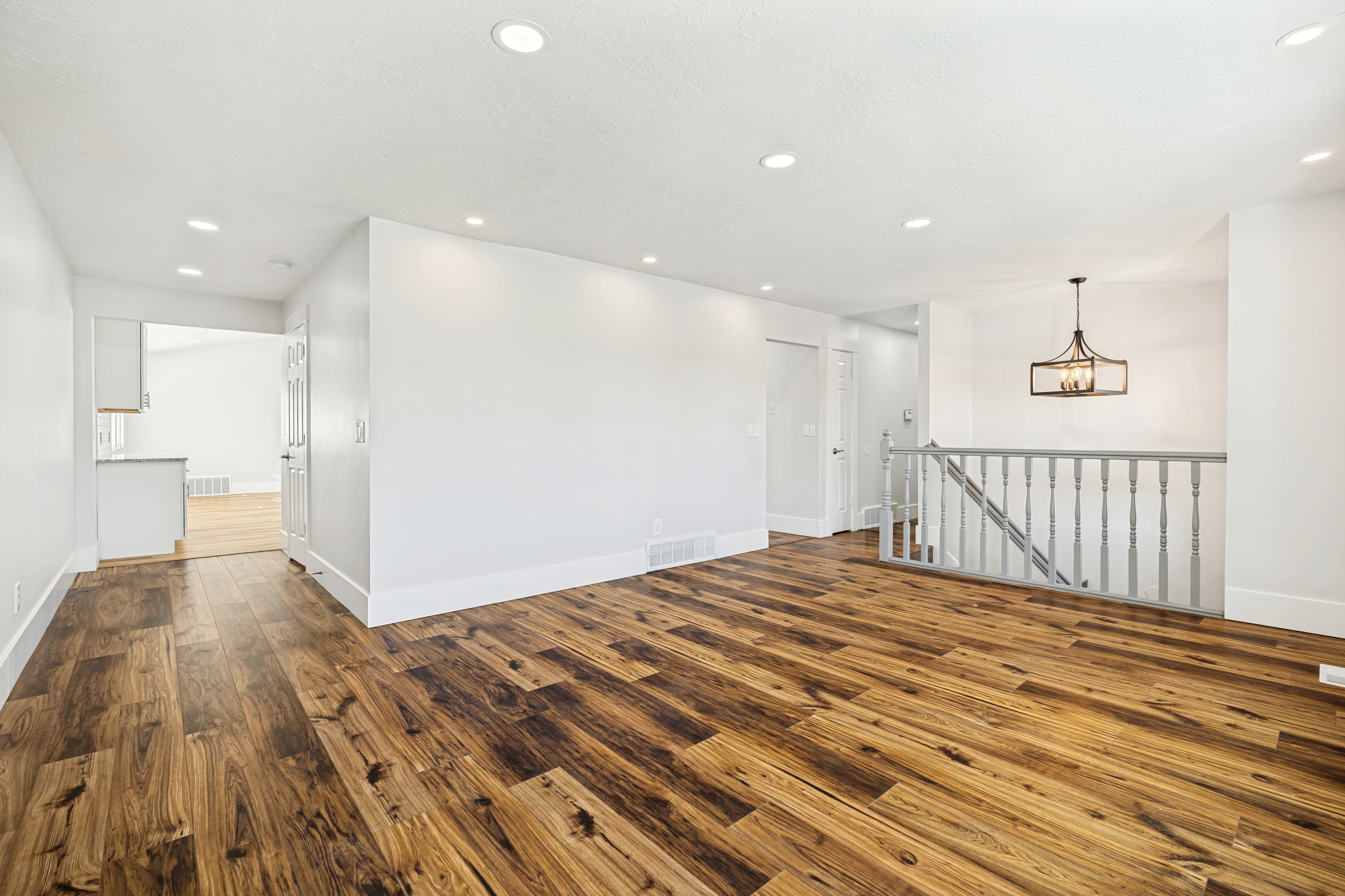 Spacious interior featuring wood-finish flooring, recessed lighting, and a contemporary chandelier