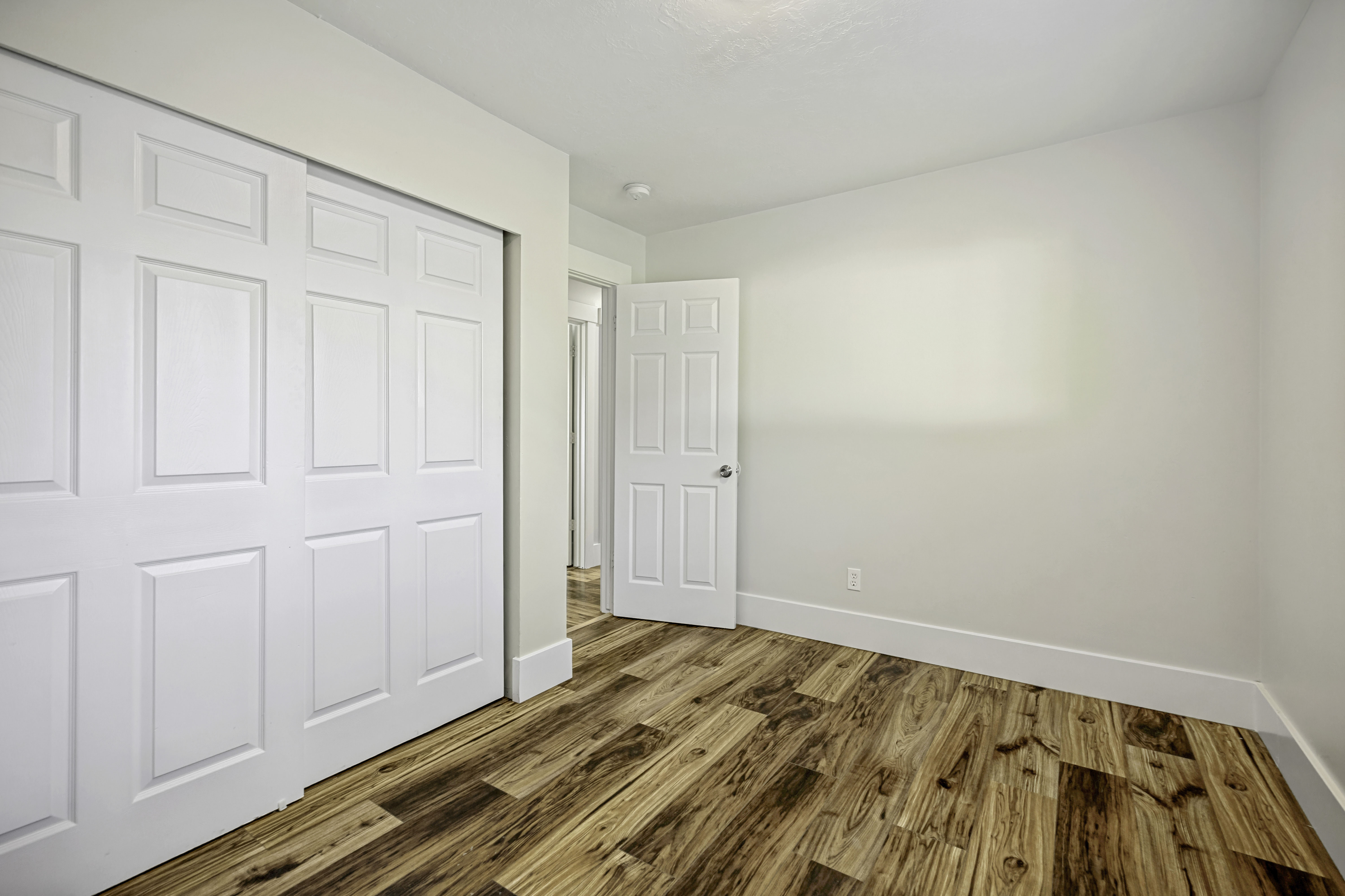 Room featuring wood-finish flooring, crisp white walls, and a recessed ceiling light
