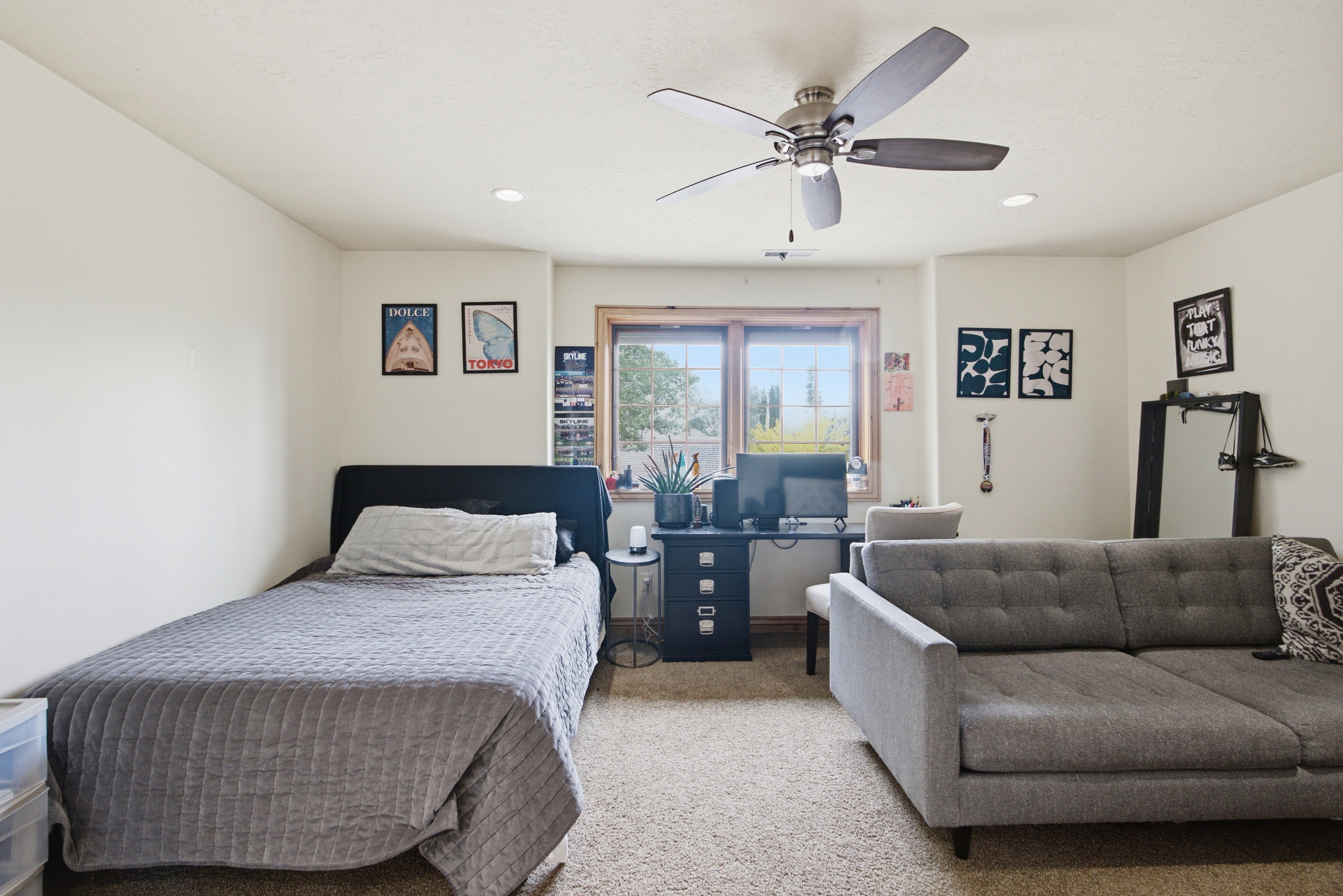 Carpeted room featuring a ceiling fan with integrated lighting, recessed lighting, and a double-pane window with wood trim