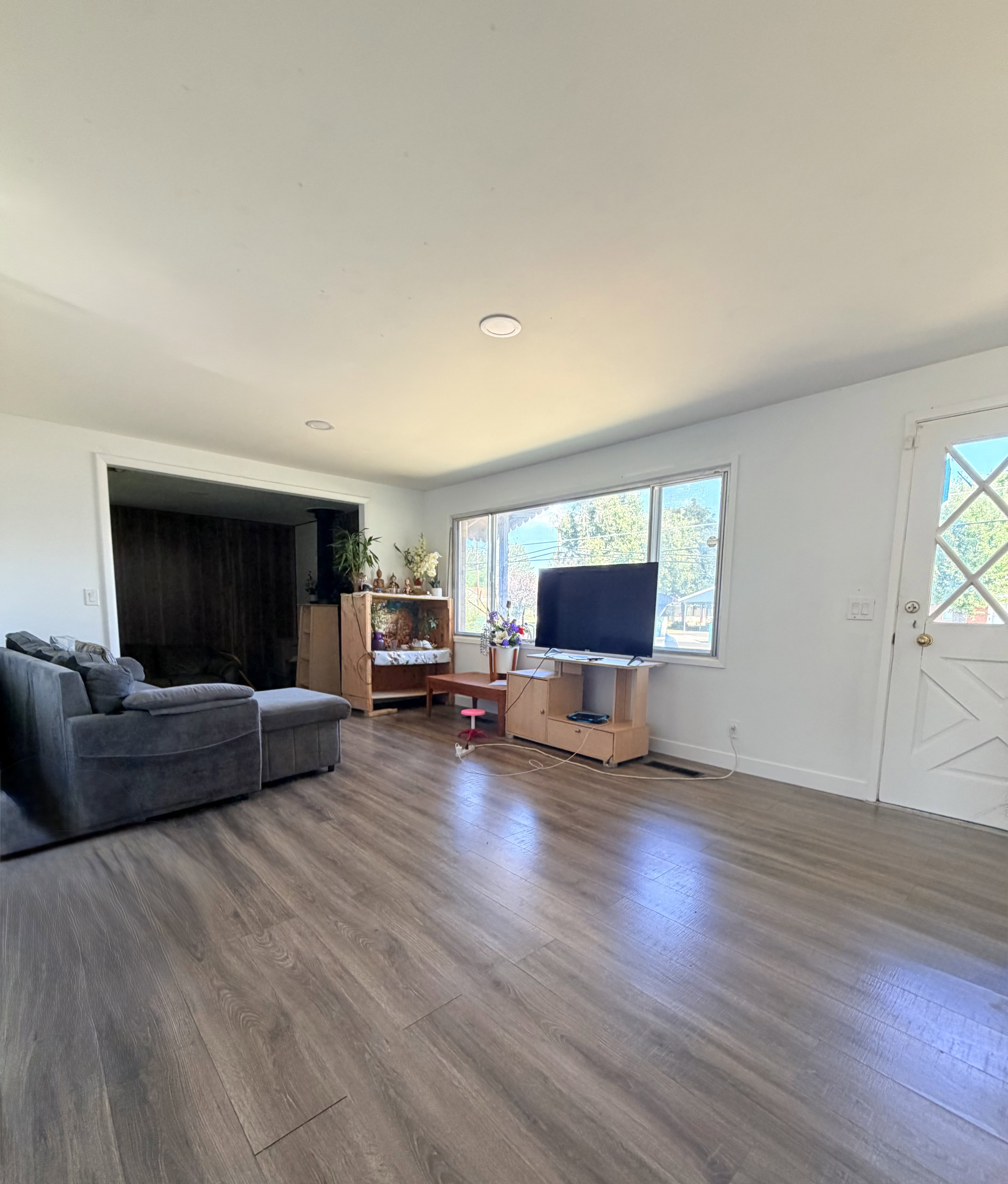 Spacious living area featuring wood-finish flooring, recessed lighting, and white walls