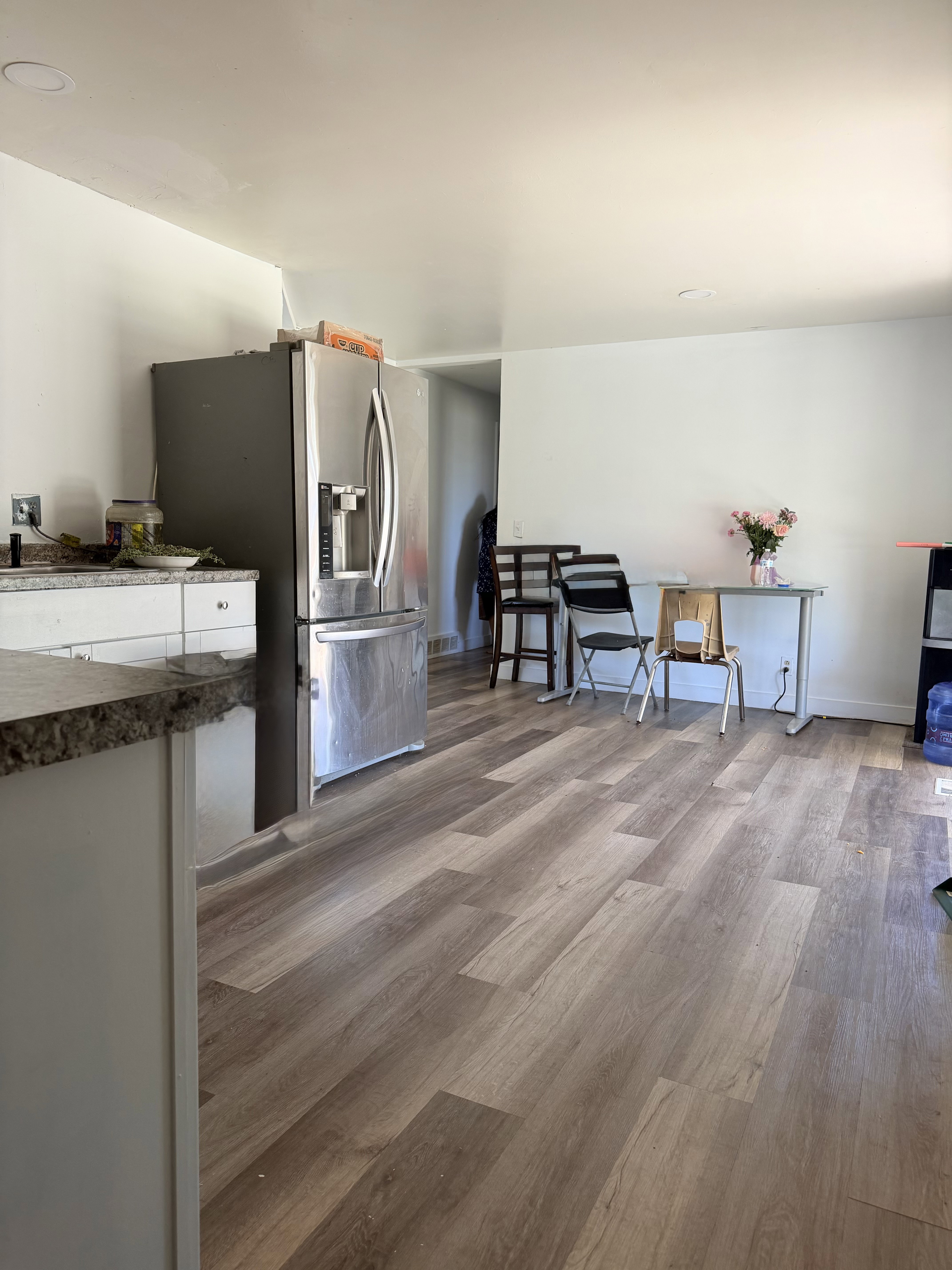 Open-concept kitchen area featuring wood-finish flooring, white walls, and recessed lighting