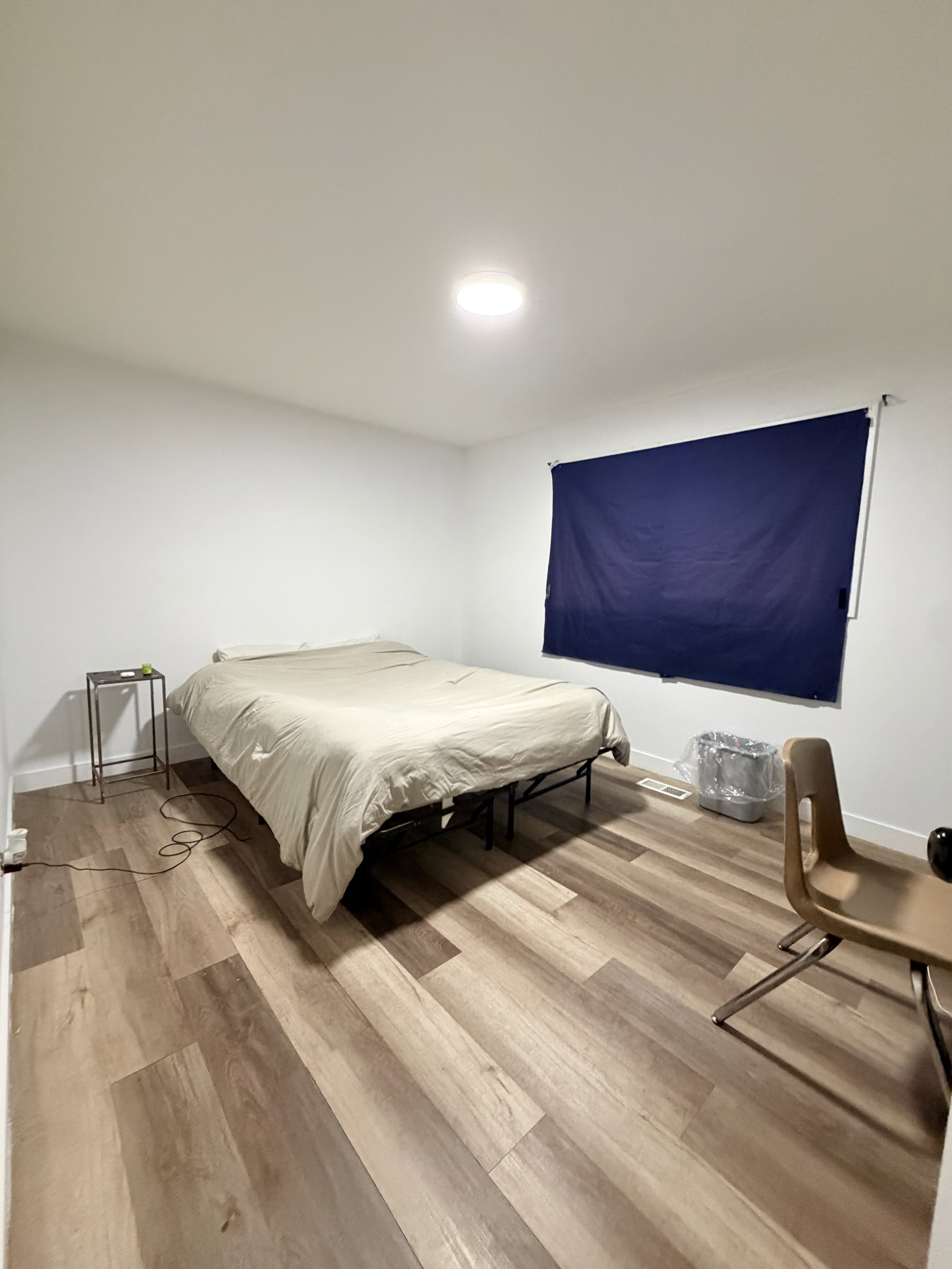 Spacious room featuring wood-finish plank flooring and white walls