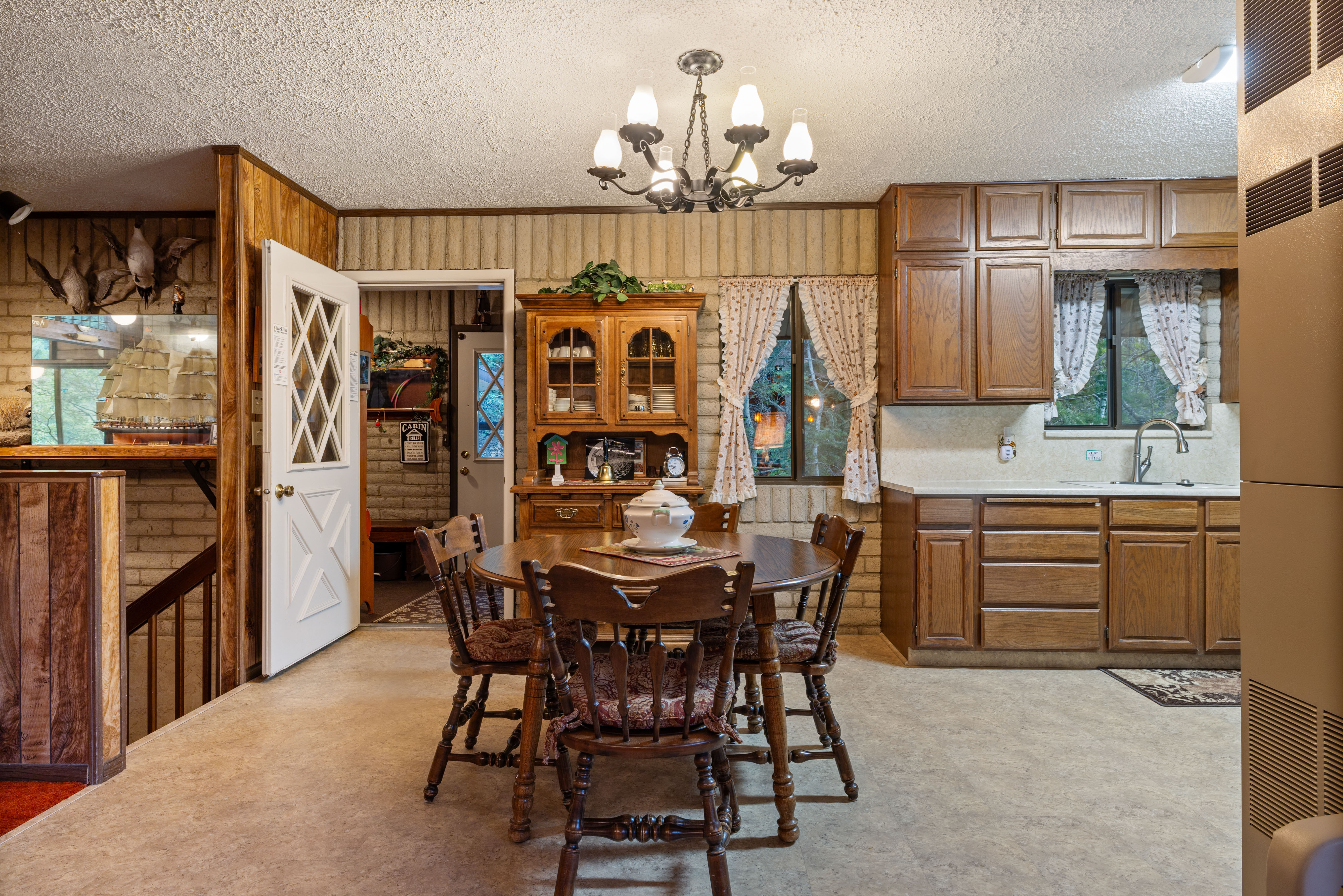 Functional kitchen area with wood-finish cabinetry, a single basin sink, and a light-colored countertop