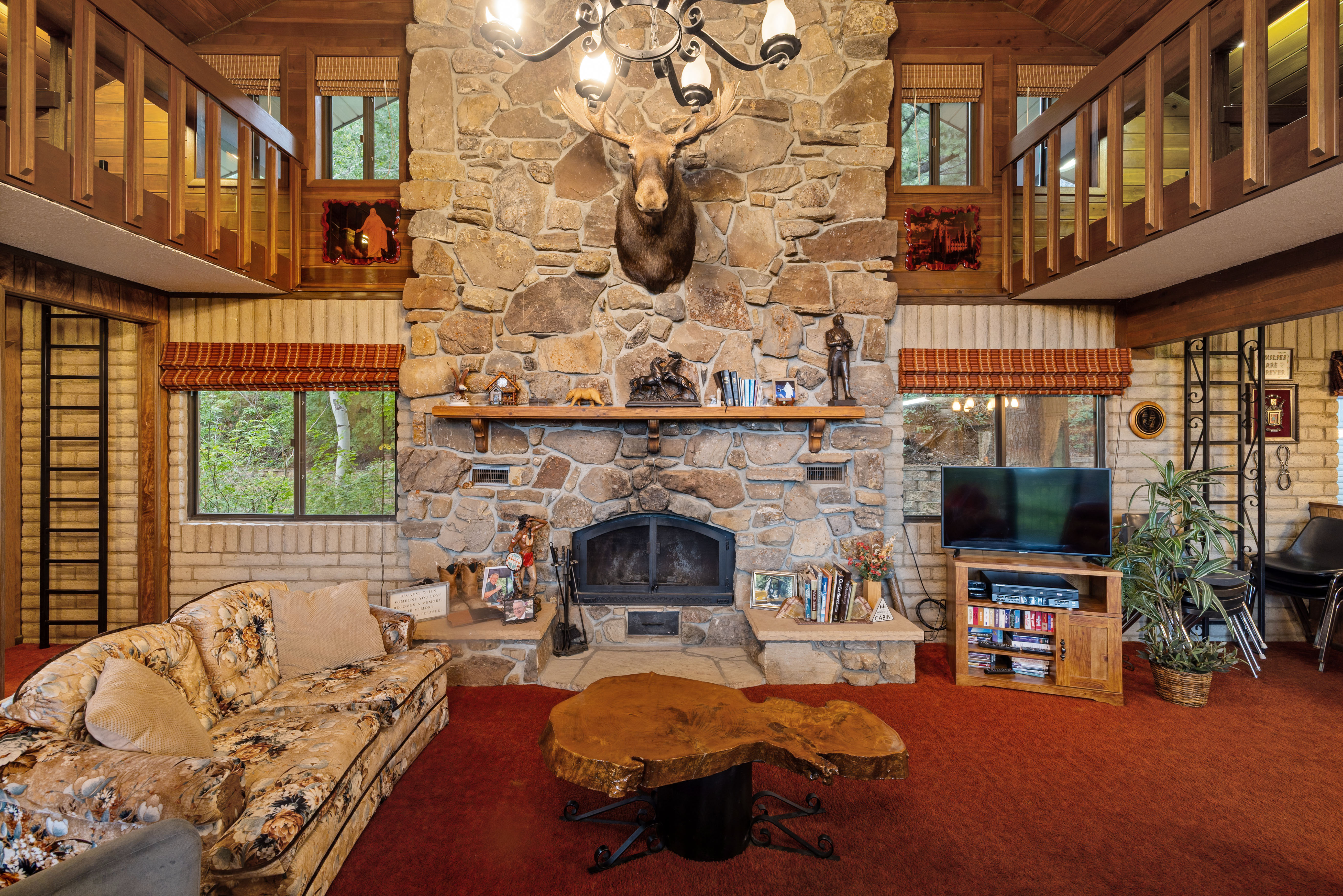 Great room featuring a floor-to-ceiling stone fireplace with a wood mantel