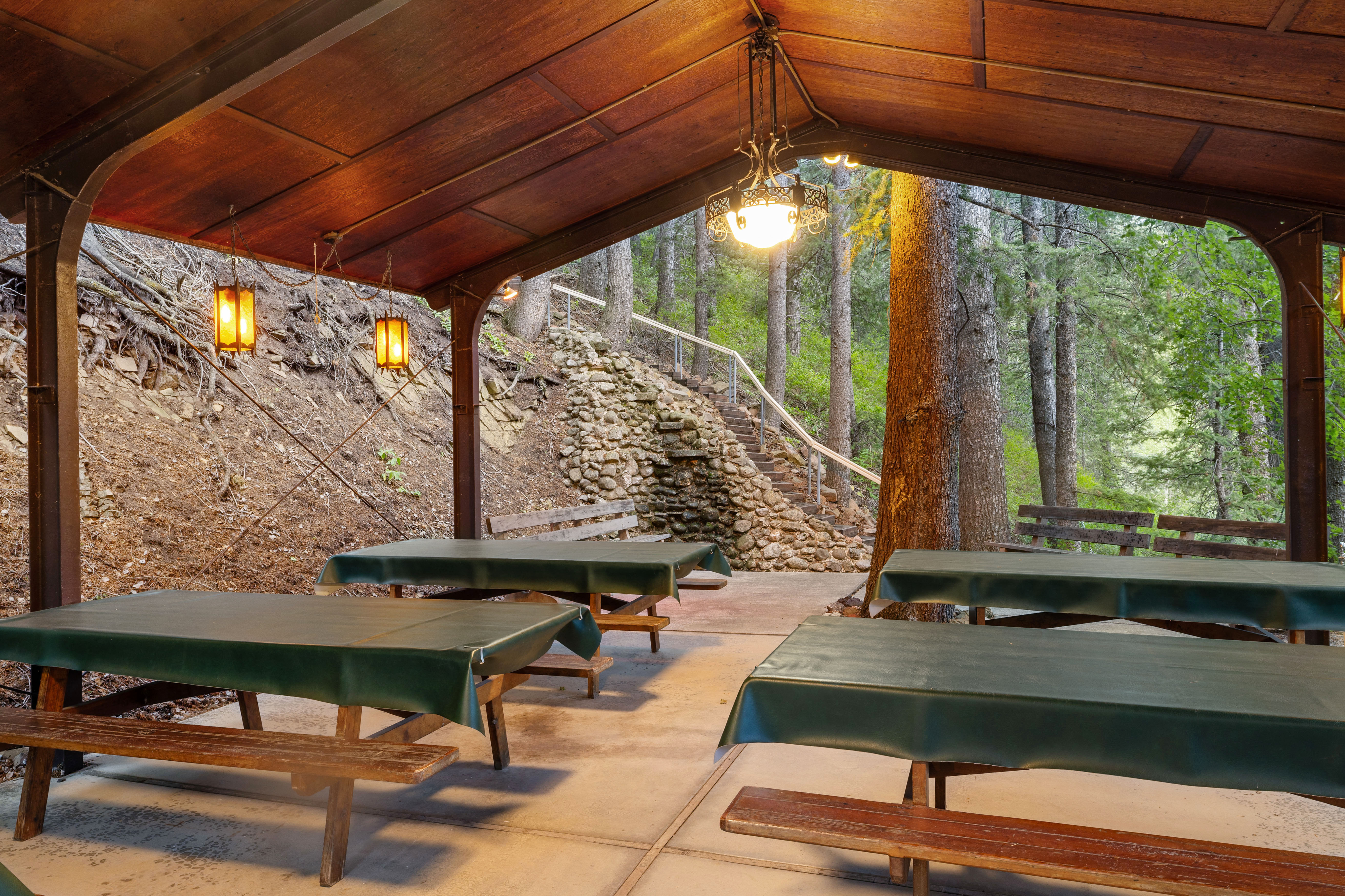 Pavilion featuring a sloped wood-paneled ceiling, exposed support beams, and concrete flooring