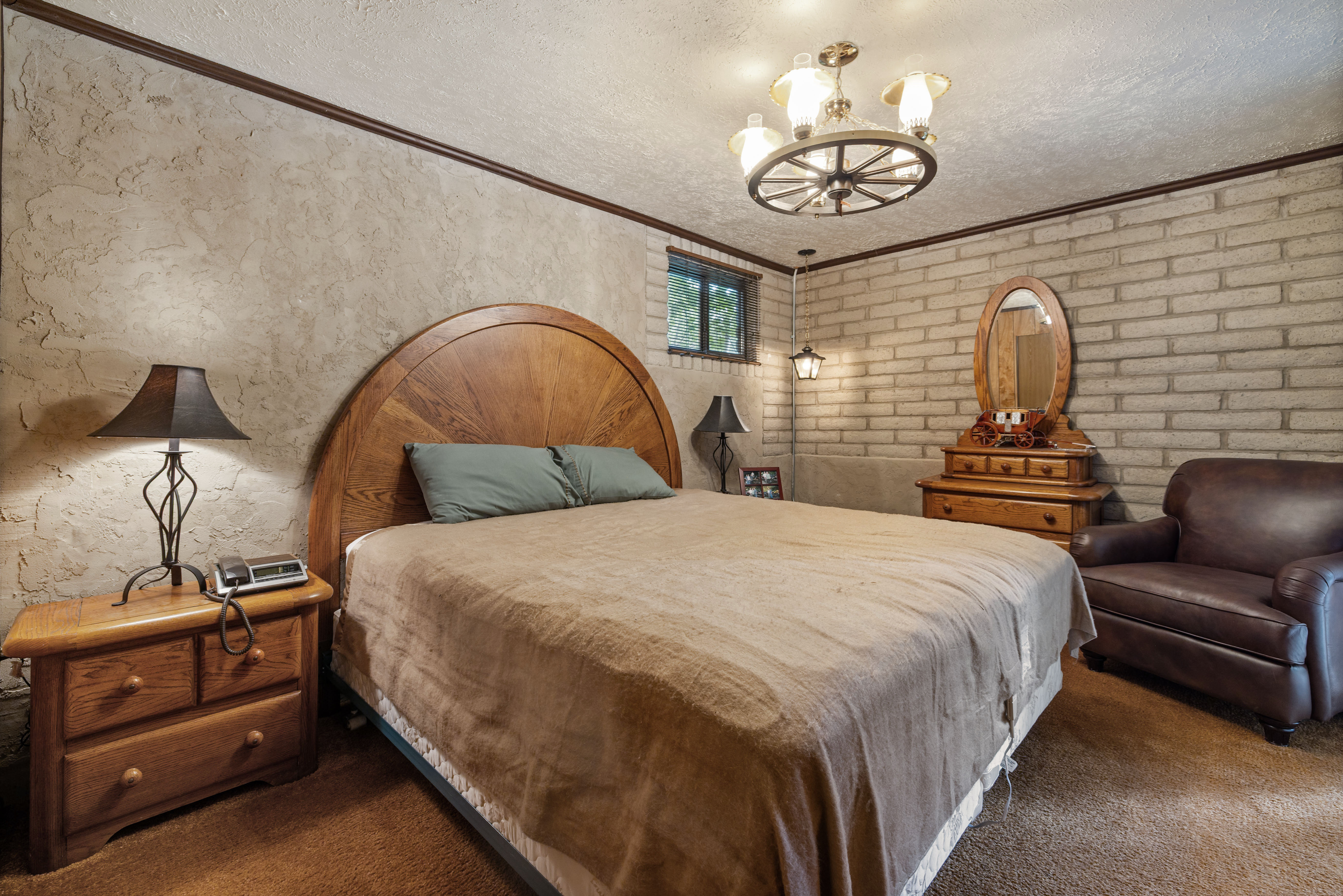 Bedroom with Textured wall finishes with decorative trim, complemented by a brick-style accent wall.