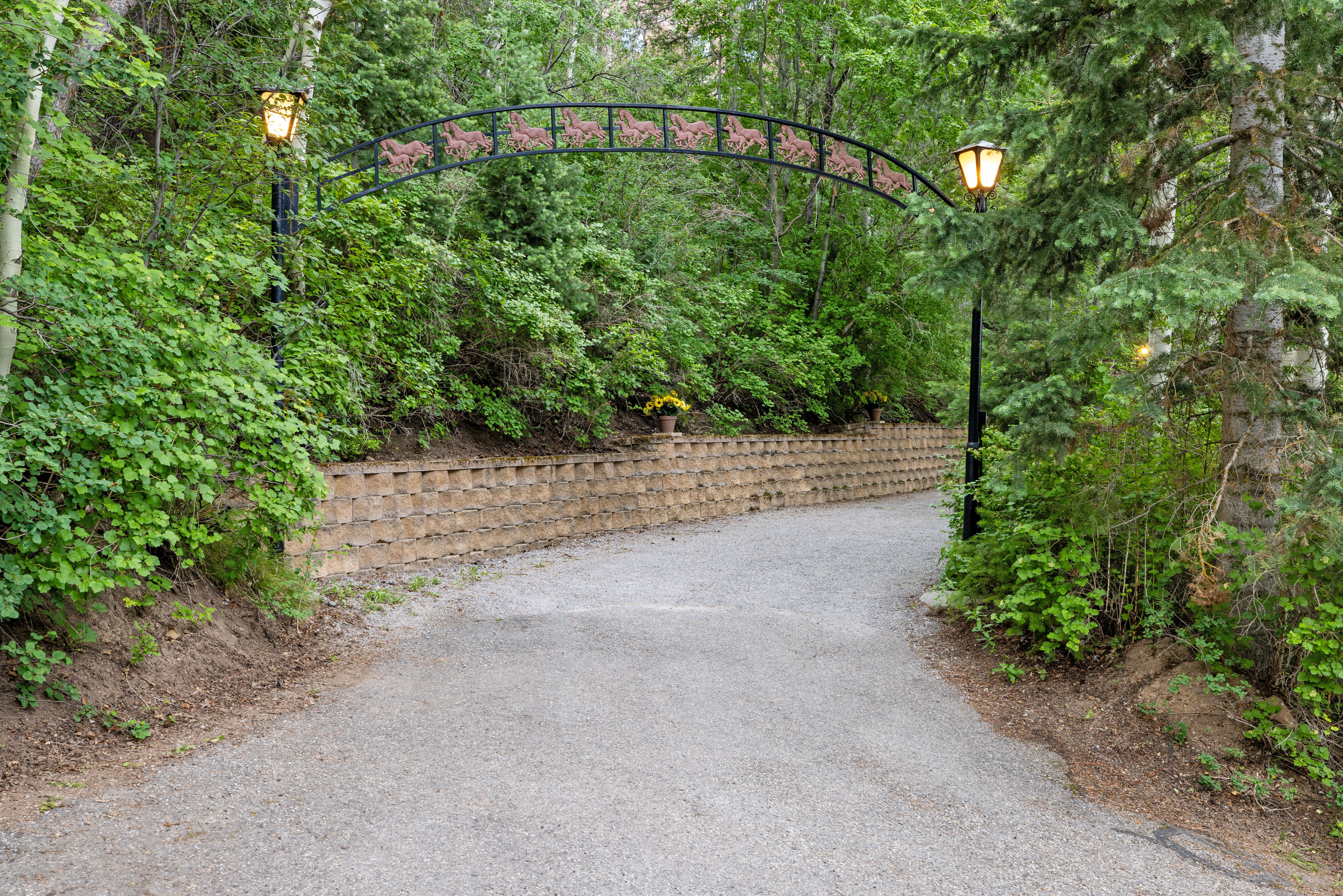 Gravel driveway flanked by a stacked block retaining wall