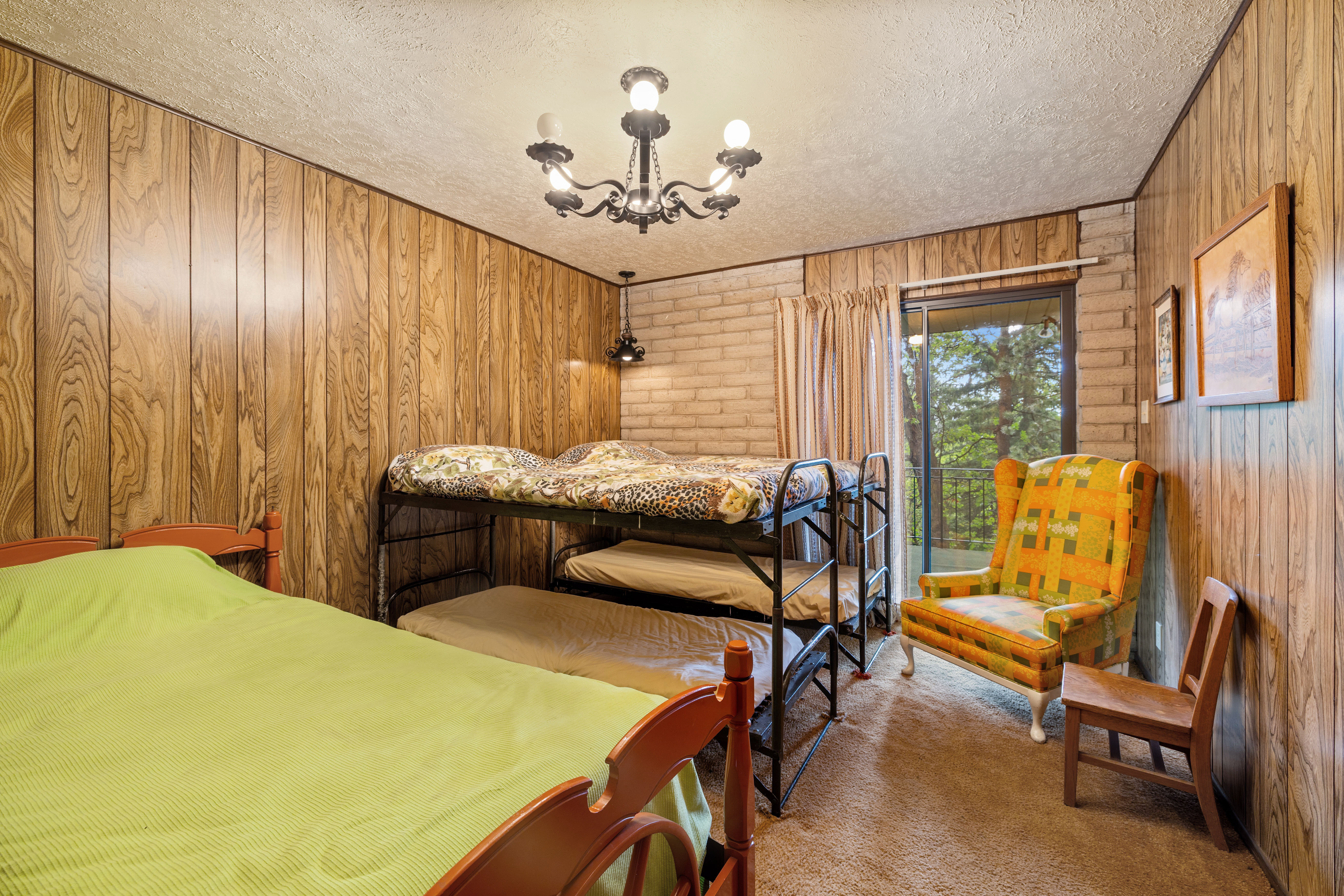 Bedroom featuring wood-panel walls and a sliding glass door providing external access