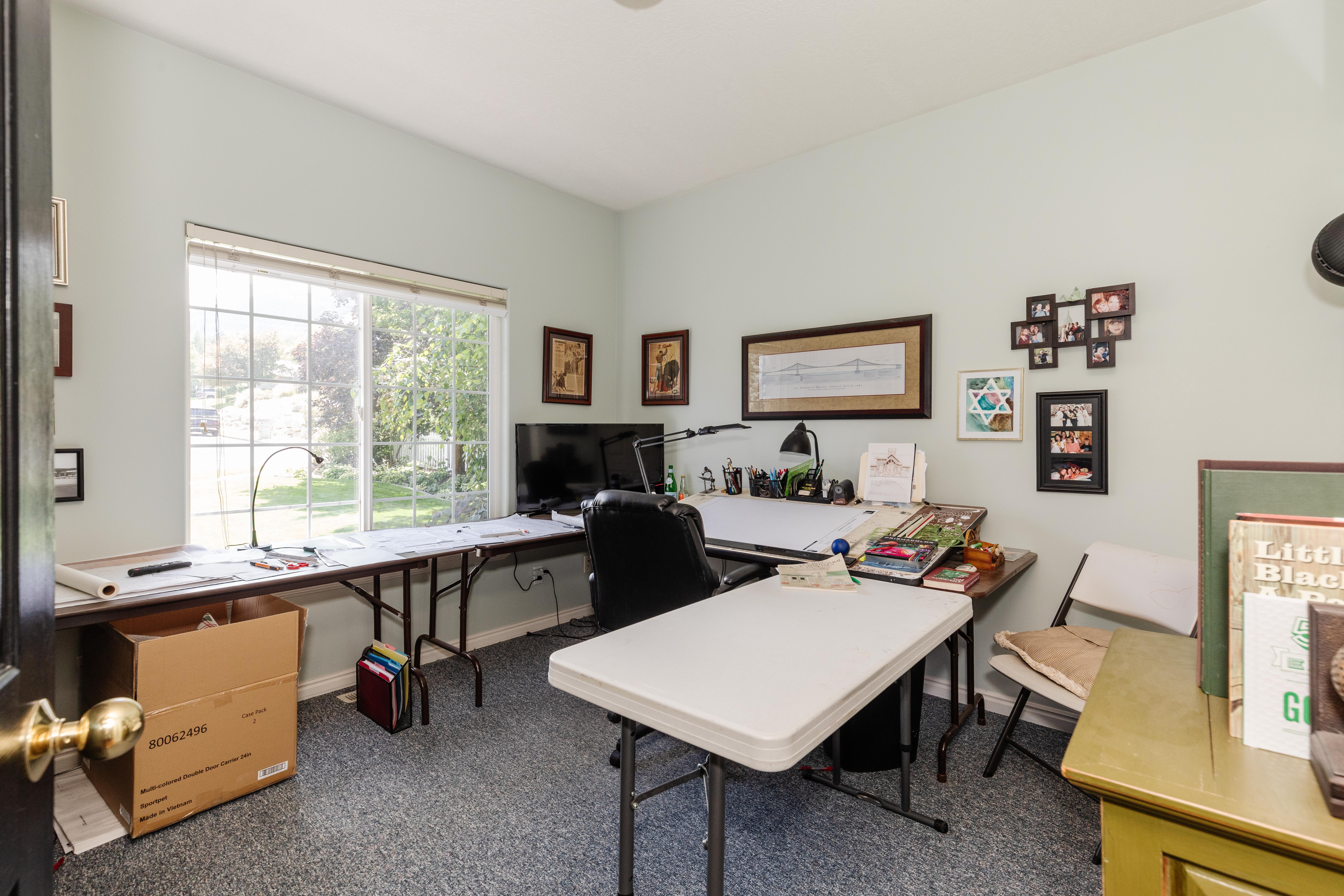 Room featuring a large window, light-colored walls, and textured carpet flooring