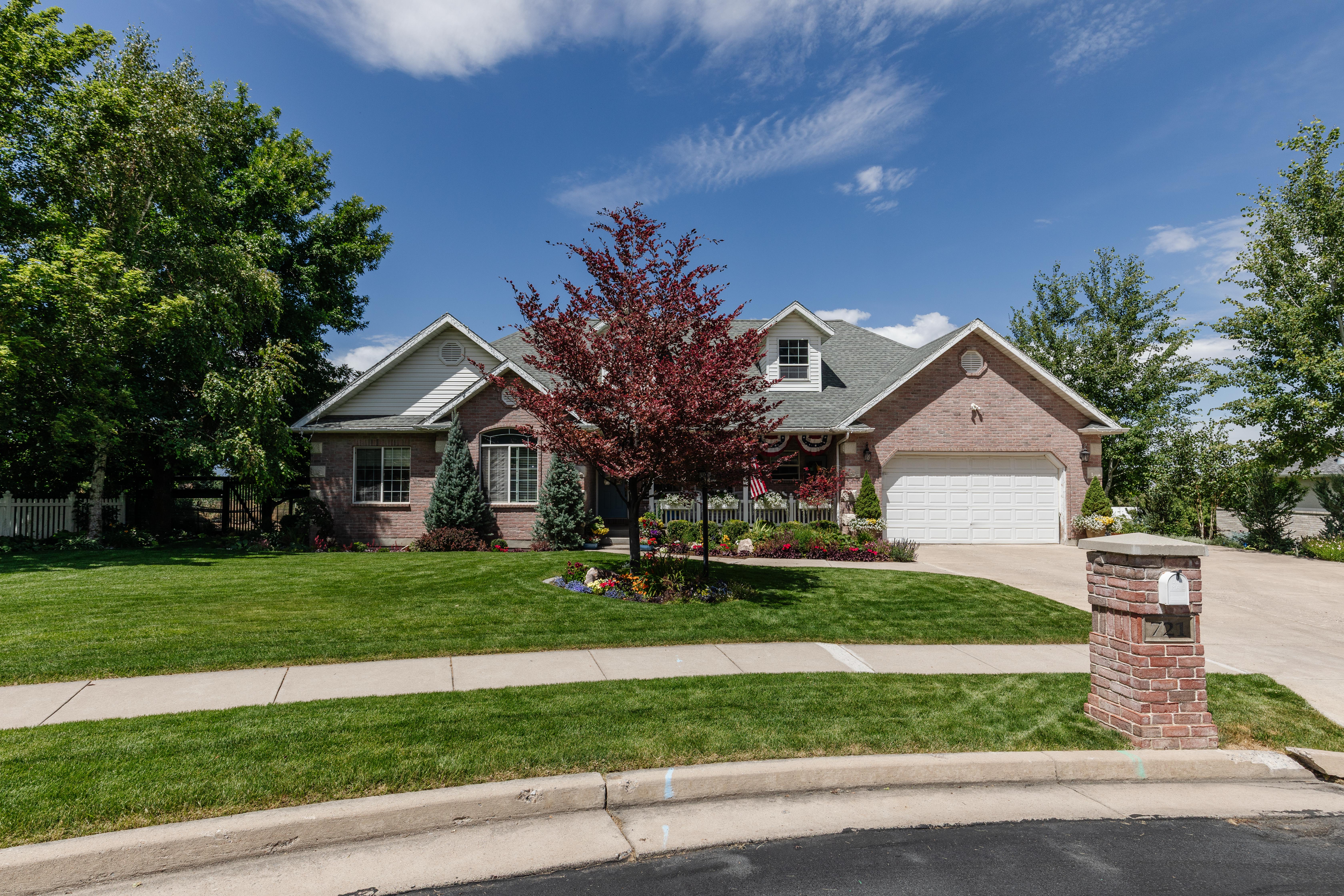 Brick exterior with a peaked roofline, front-facing dormer, and a two-car garage
