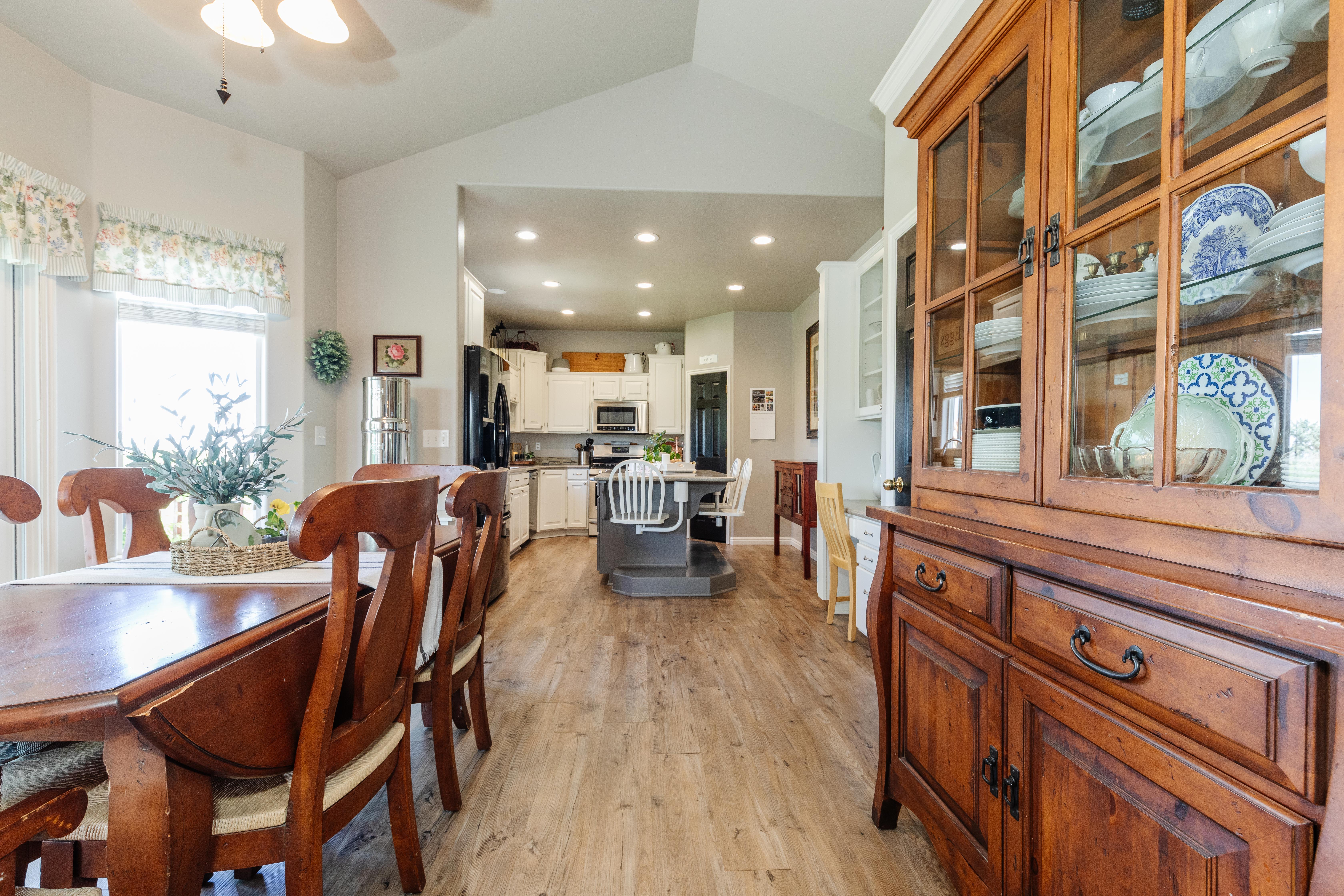 Open-concept living space featuring wood-finish flooring throughout, a vaulted ceiling, and recessed lighting