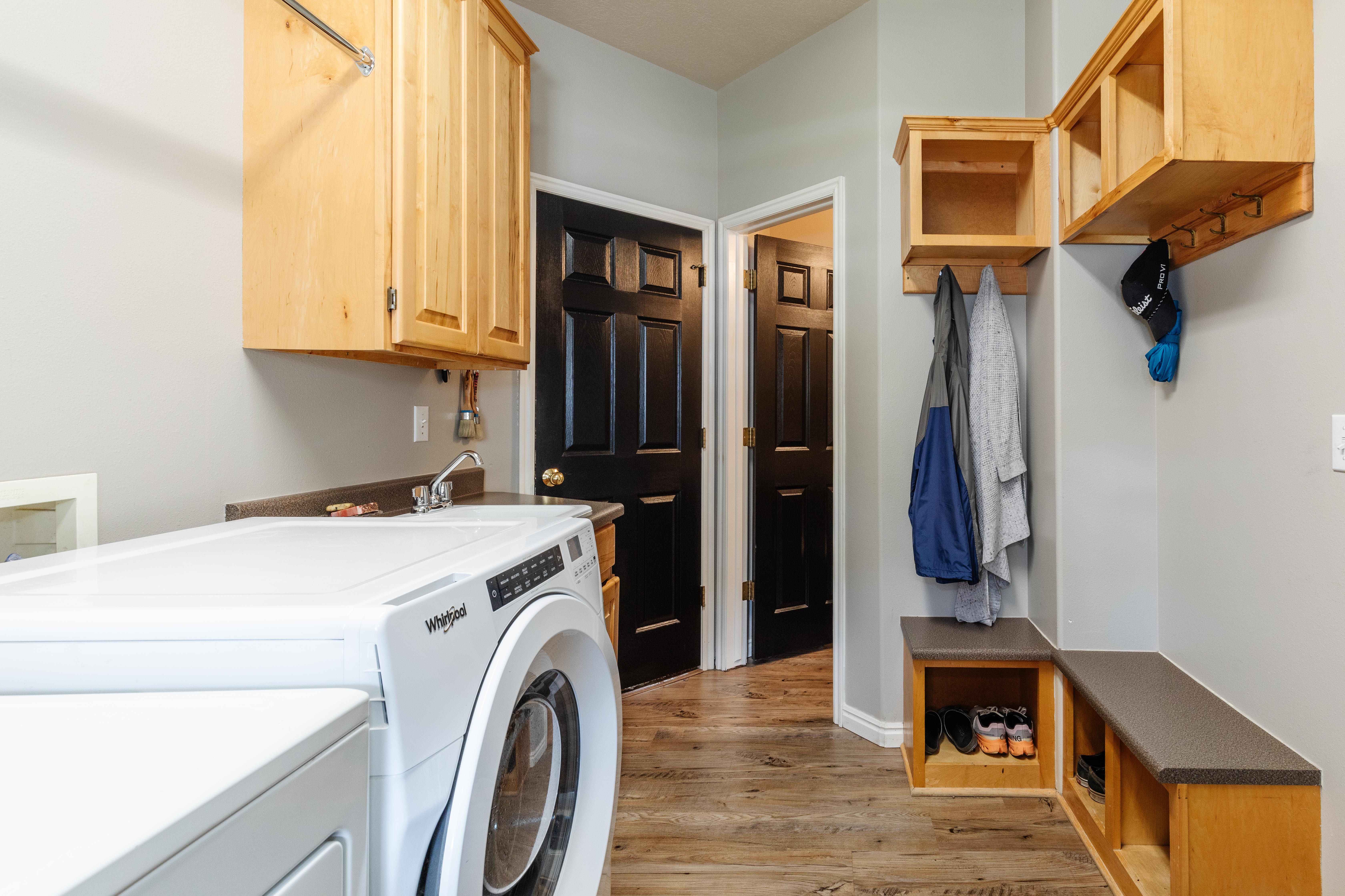 Laundry area featuring a utility sink, solid surface countertop, and wood-finish flooring