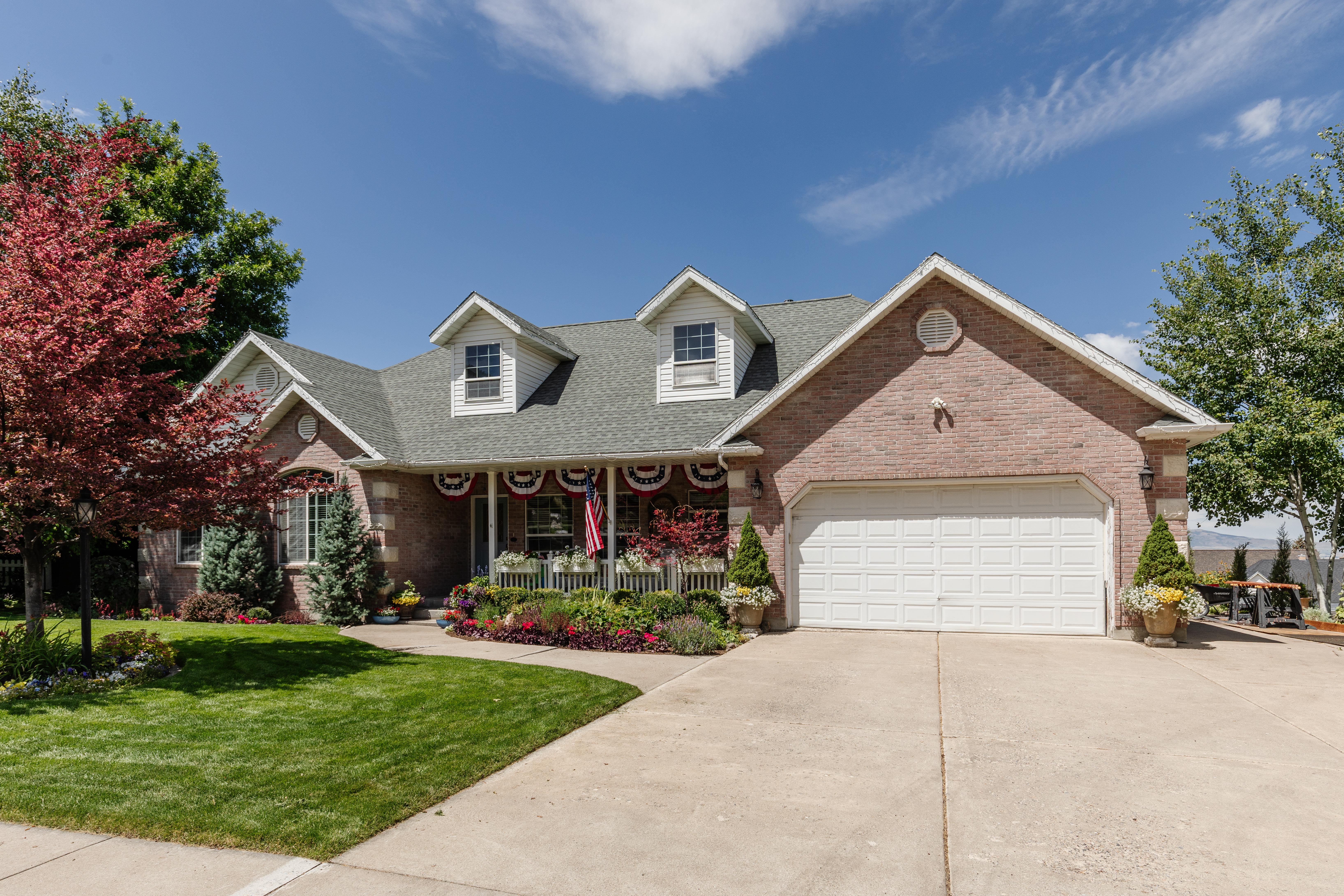 Brick exterior with dormer windows and a covered front porch