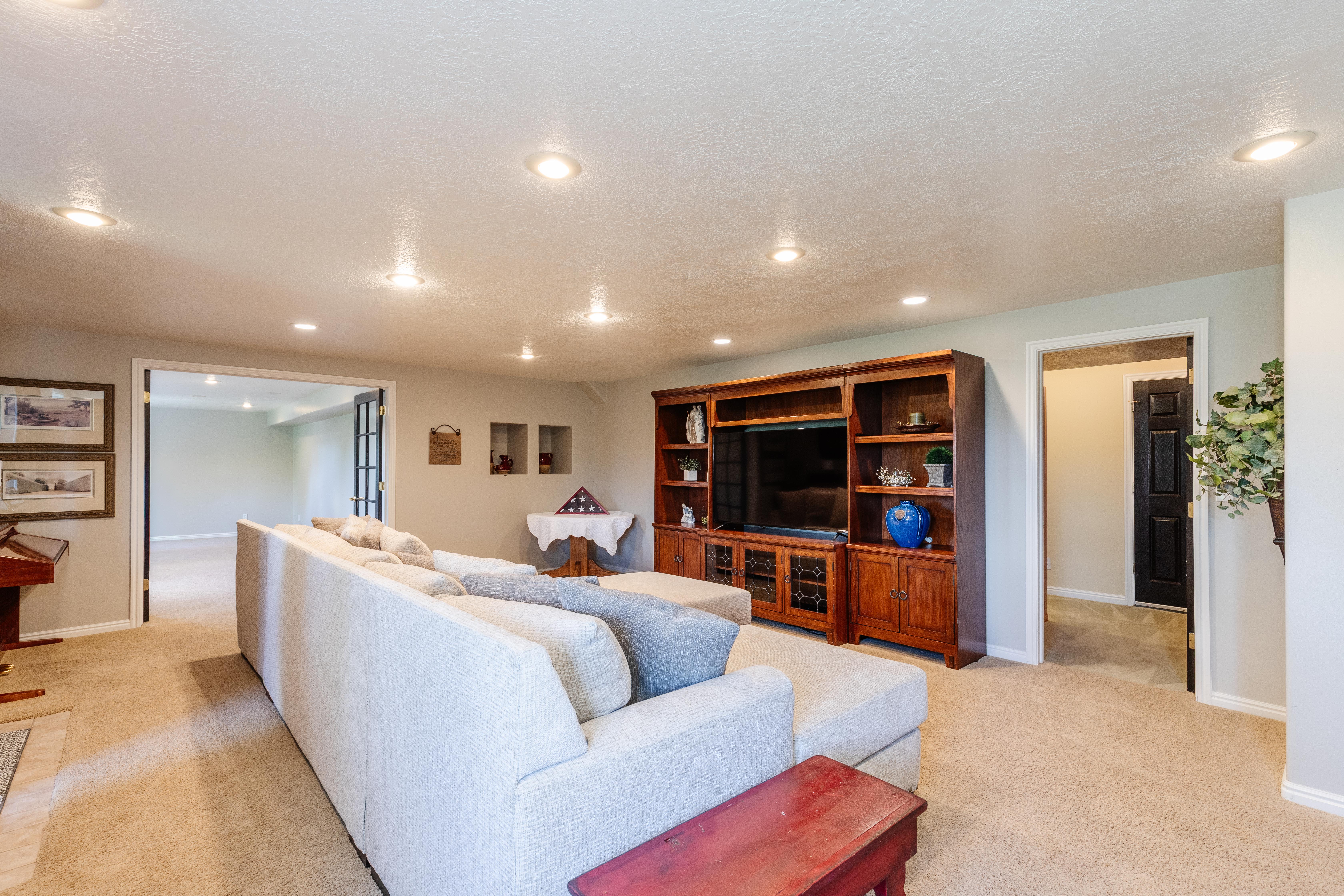 Spacious living area featuring recessed lighting, light-toned carpeting, and a built-in wood entertainment center