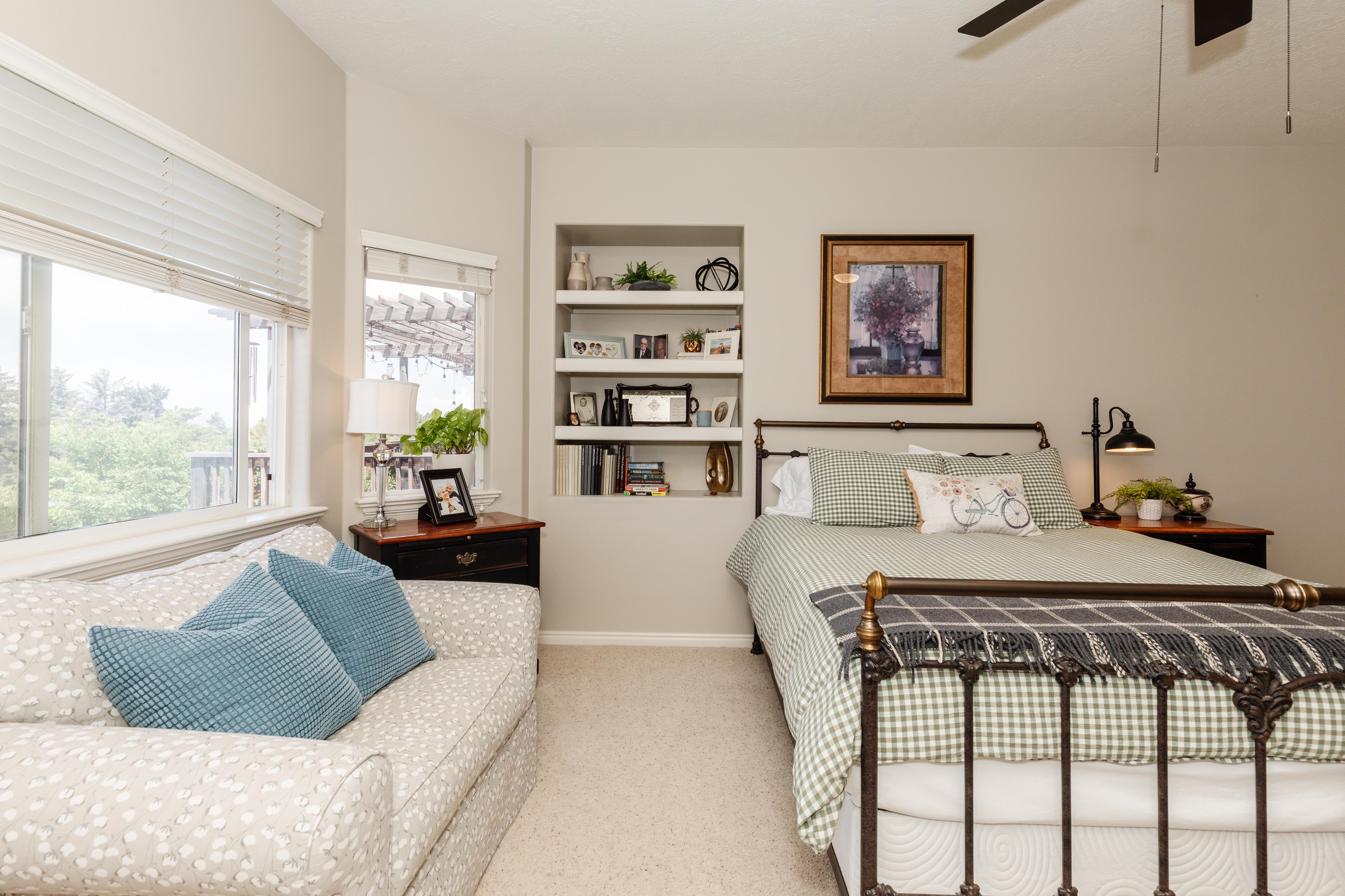 Bedroom featuring a metal bed frame, built-in shelving, and light-toned walls