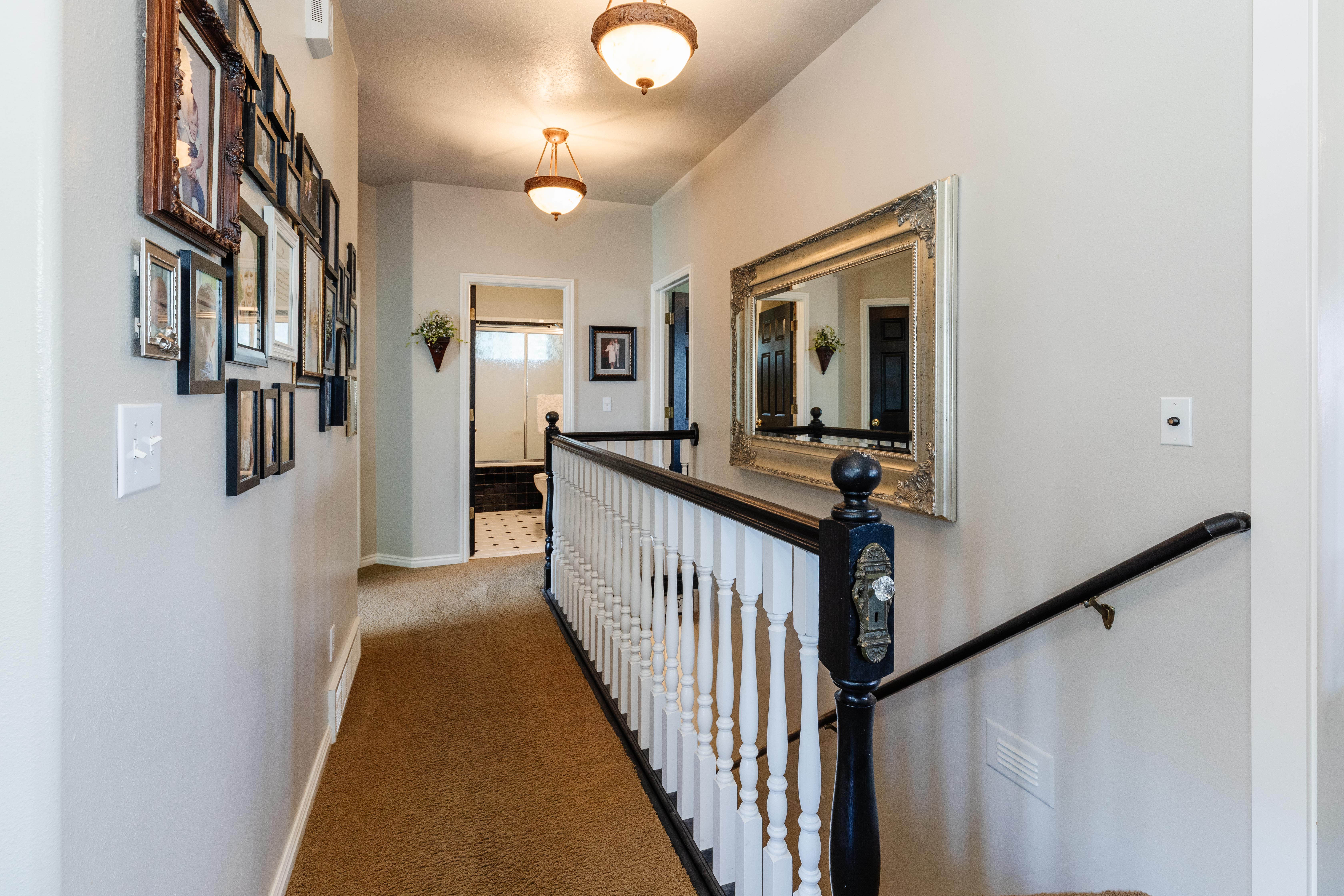 Upper-level hallway featuring warm-toned carpet flooring and neutral wall paint