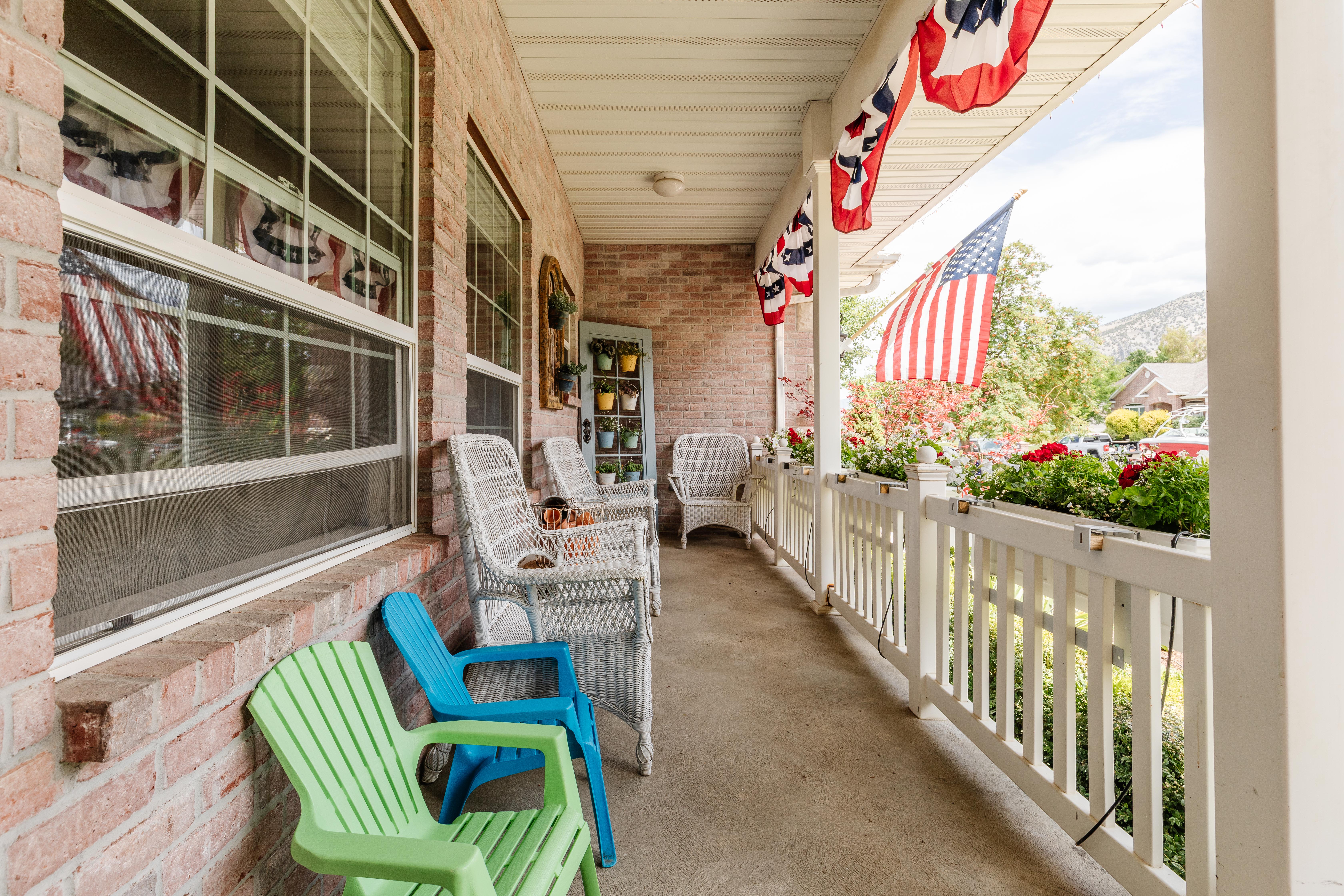 Inviting front porch featuring a brick facade, white railing with planter boxes, and a light-colored soffit
