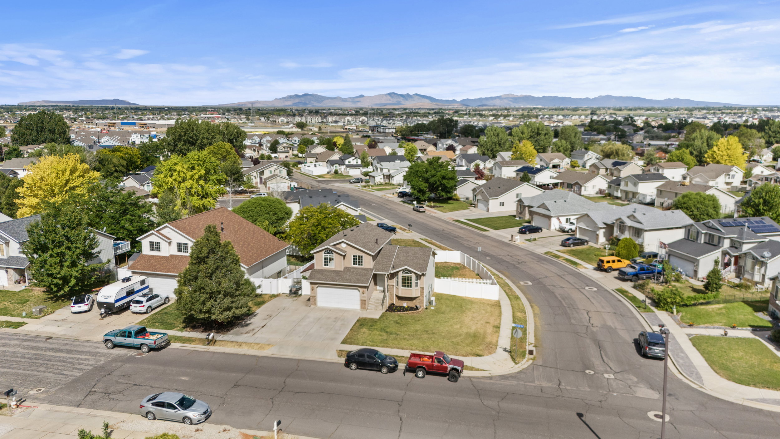 Aerial view of a residential neighborhood with houses featuring a mix of architectural styles, shingled roofs, and attached garages